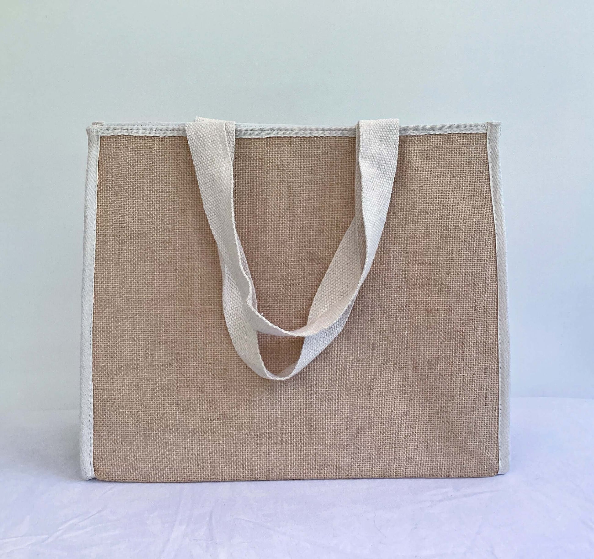 Back of bag which is all hessian, with natural calico straps hanging down.