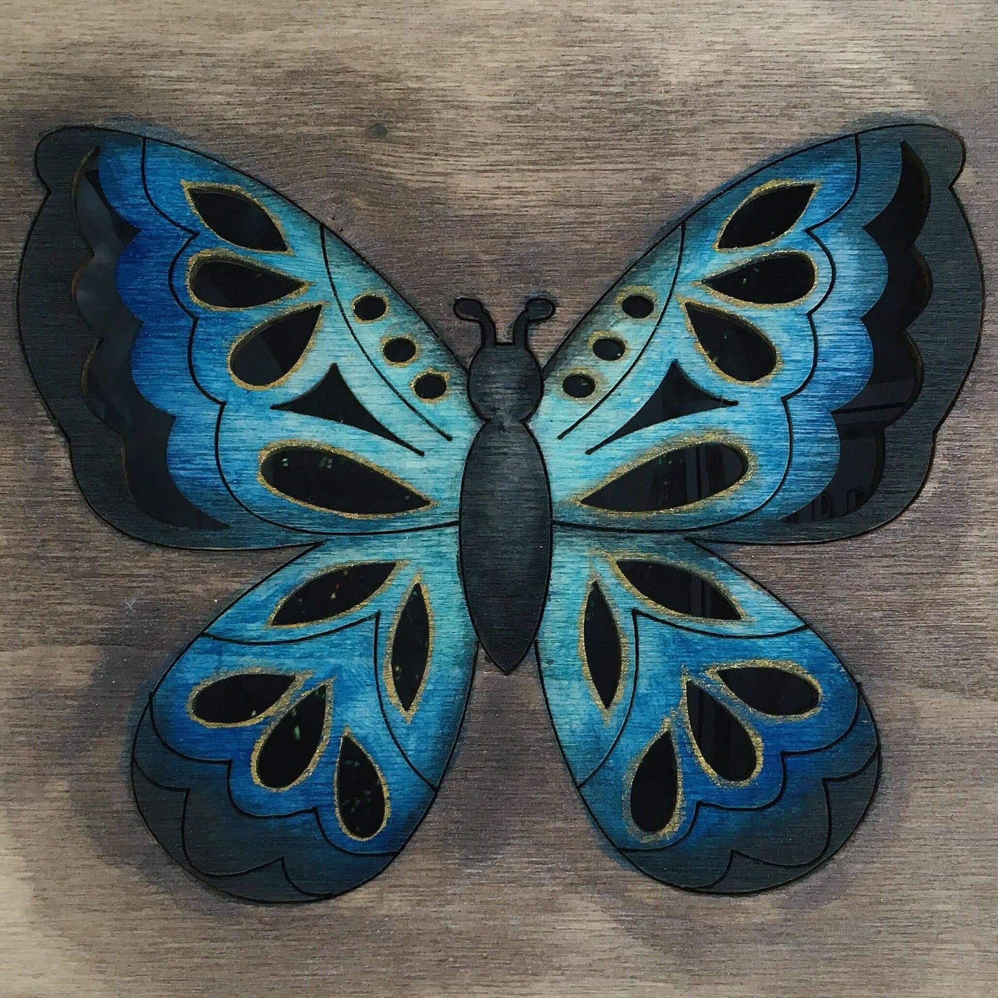 Detail view of painted lid, brown washed background, with multi blues butterfly in the center.