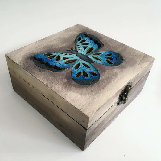 Outside view of brown painted box, with blue butterfly laser cut lid, and metal closing clasp.