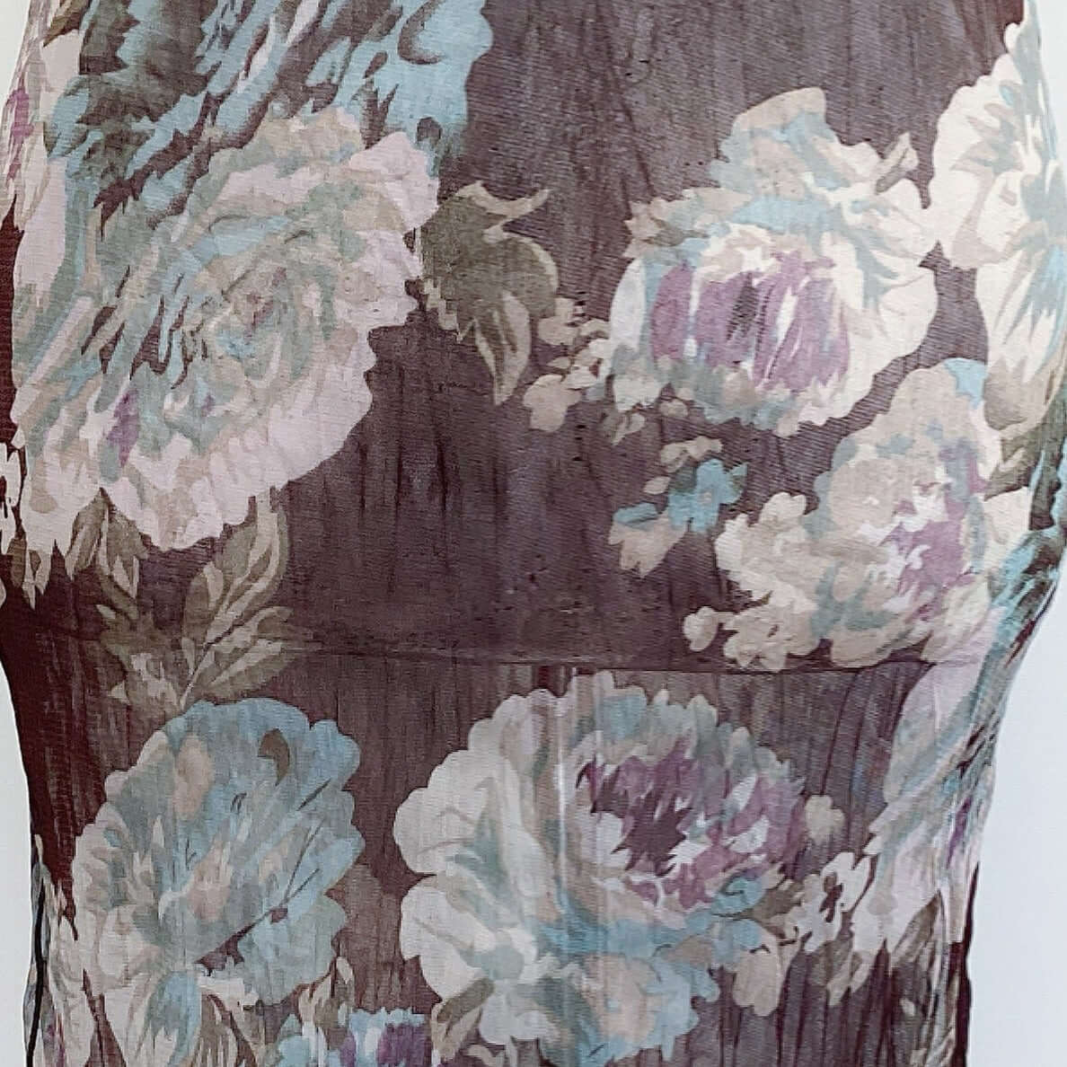 Close up of printed stretch mesh cami, brown background with large printed beige, turquoise, lilac flowers.