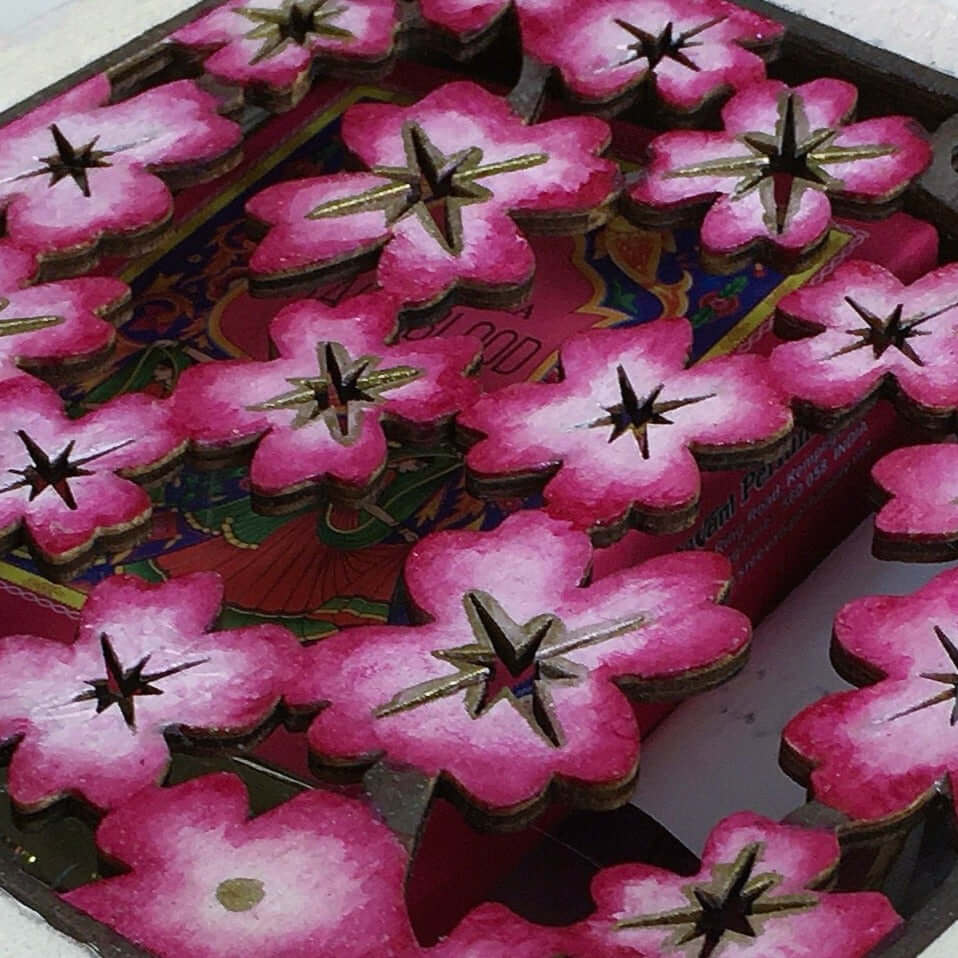 Detail view of pink painted box, fading to white and pink cherry blossom laser cut lid.