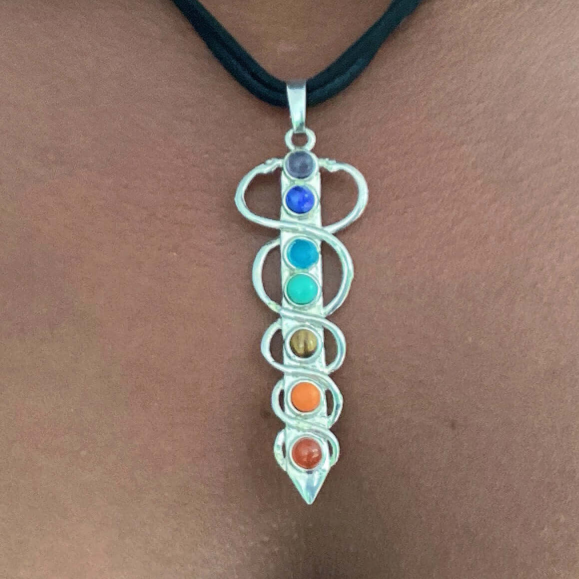 Closeup view of chakra colored stones in vertical carduceus design on choker.