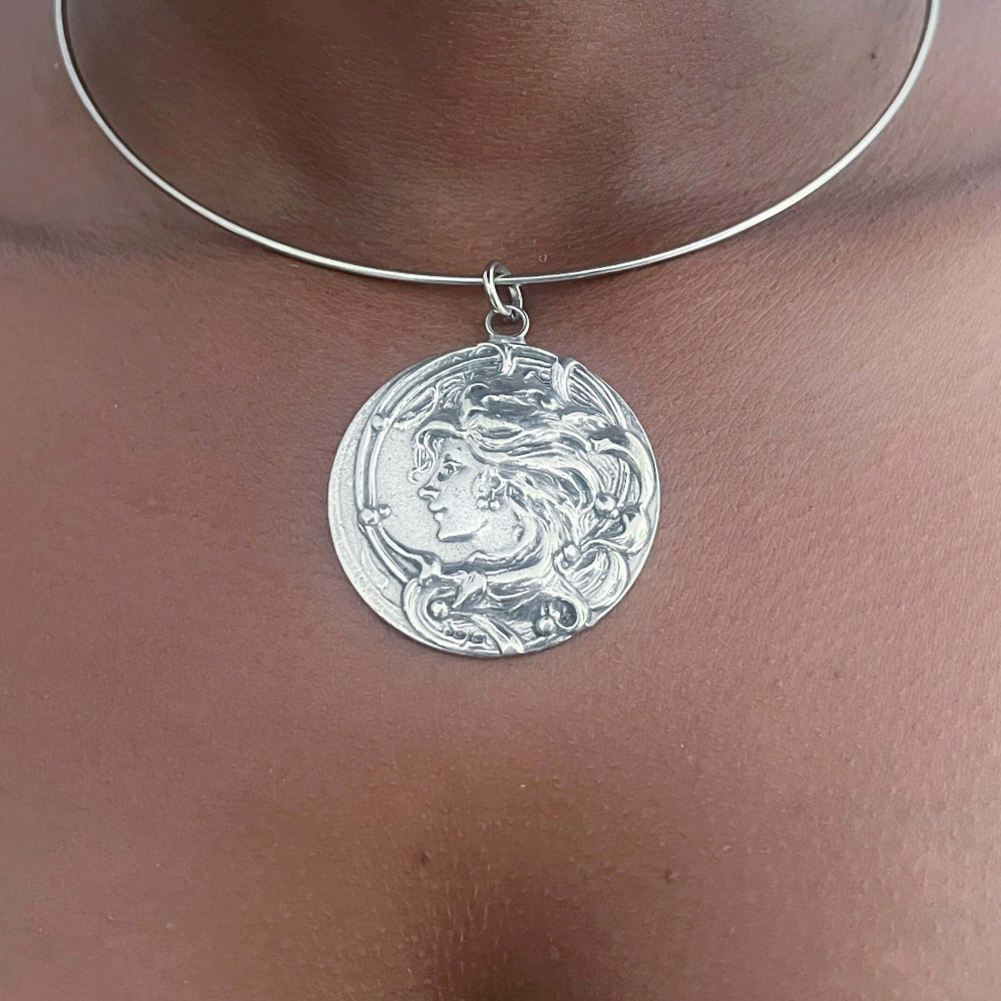 Detail view of pewter art nouveau cameo design, on metal choker.