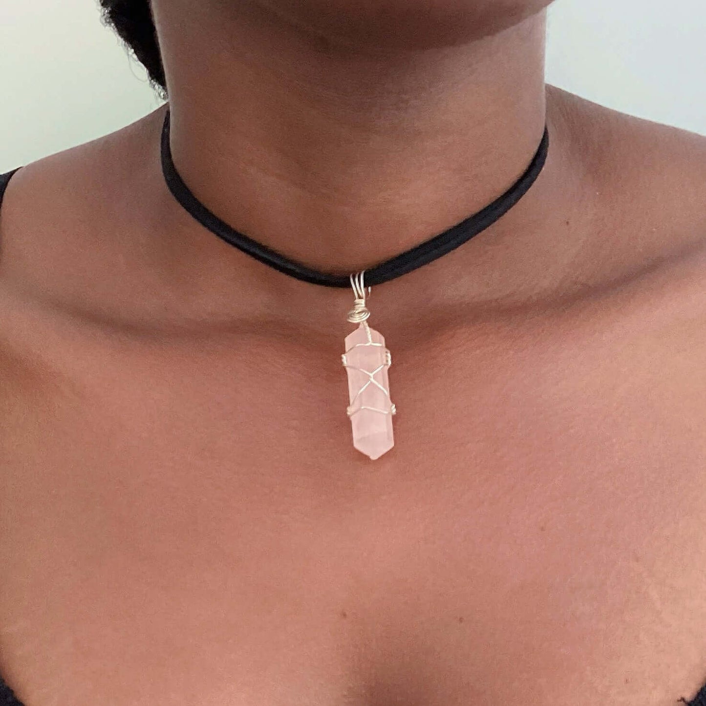 detail view of silver wire bound, cut and polished rose quartz on choker.