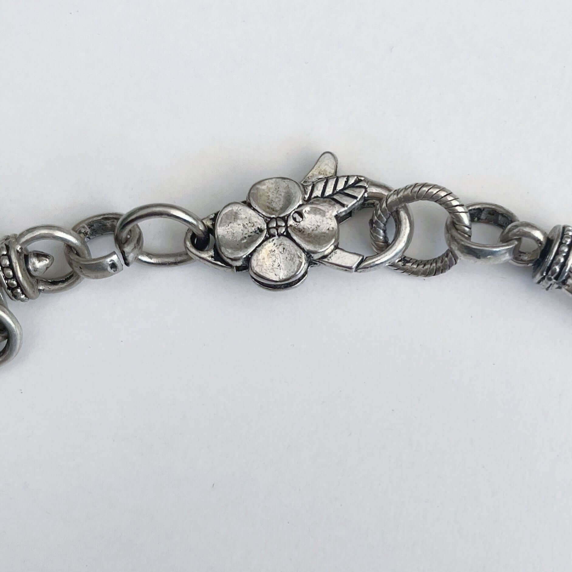 Detail view of the silver finish floral clasp.