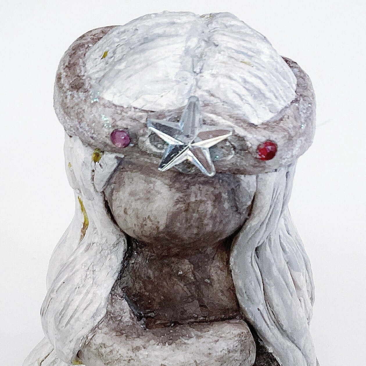 Close up of elemental, brown wash painted figure, jewel band and star on head, beige long hair.