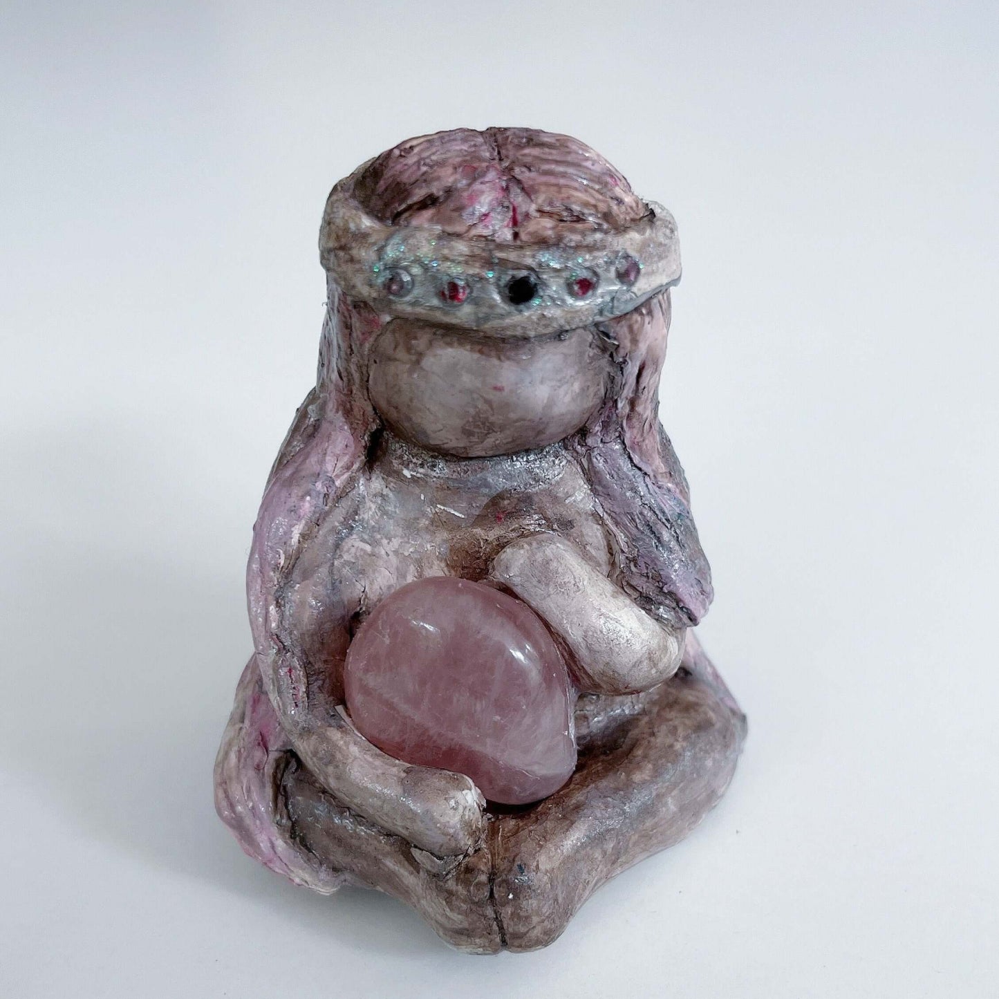 Front of elemental, brown wash painted figure, jewel band on head, pink wash long hair, holding a tumbled rose quartz.