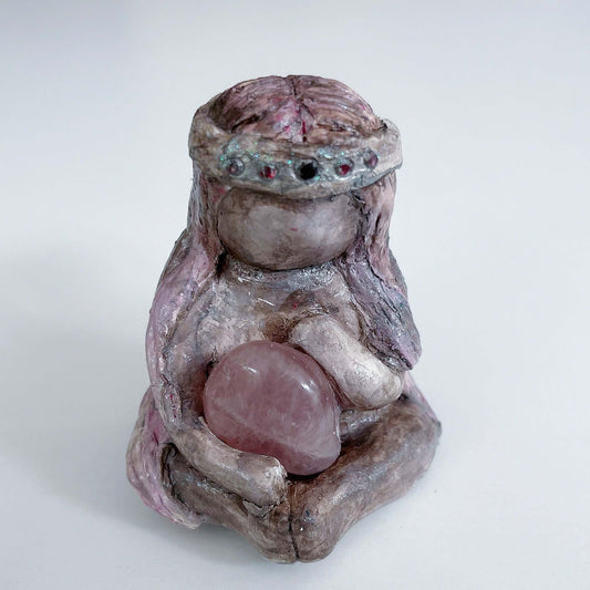 Front of elemental, brown wash painted figure, jewel band on head, pink wash long hair, holding a tumbled rose quartz.