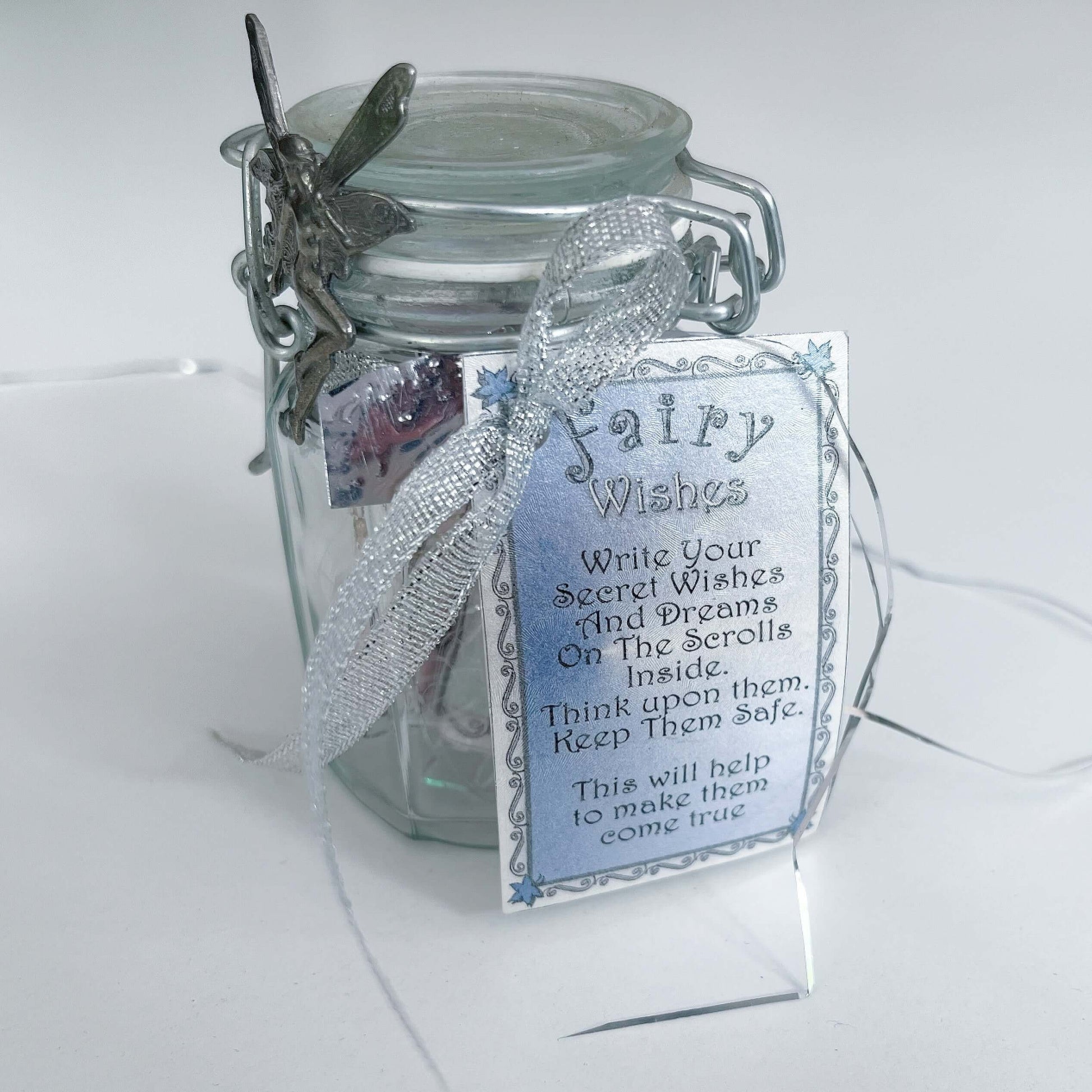 Side view of kilner style jar showing fairy attached to the lid, and ribbon attaching the inscription card.