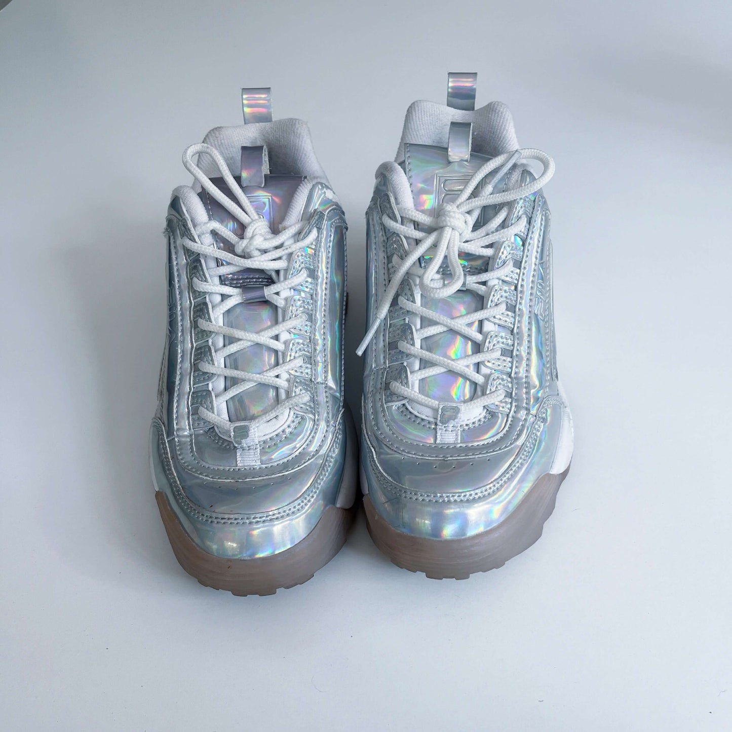 Top view of shoes, holographic material, white laces.