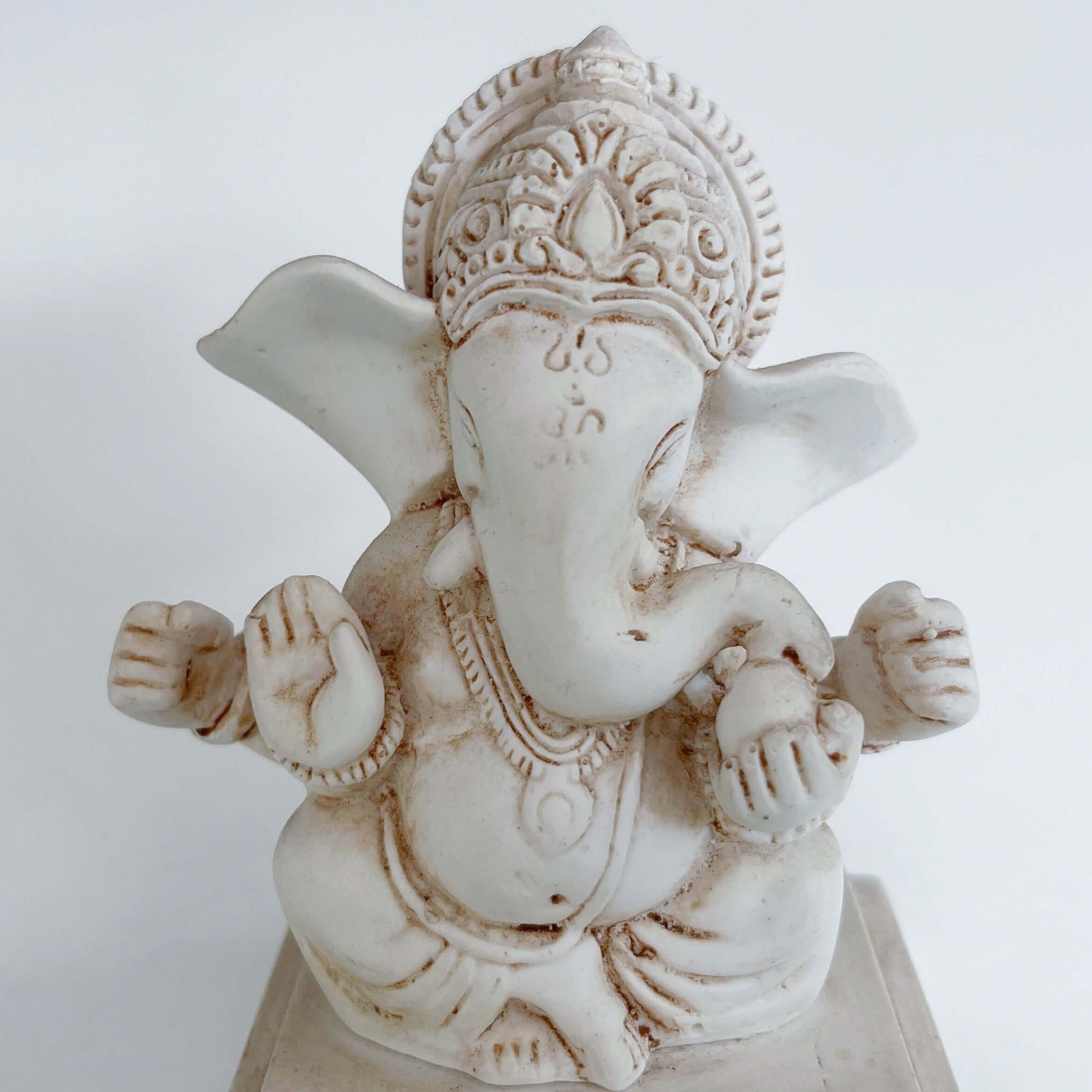 Close up view of Ganesha sitting at one end of long rectangle.