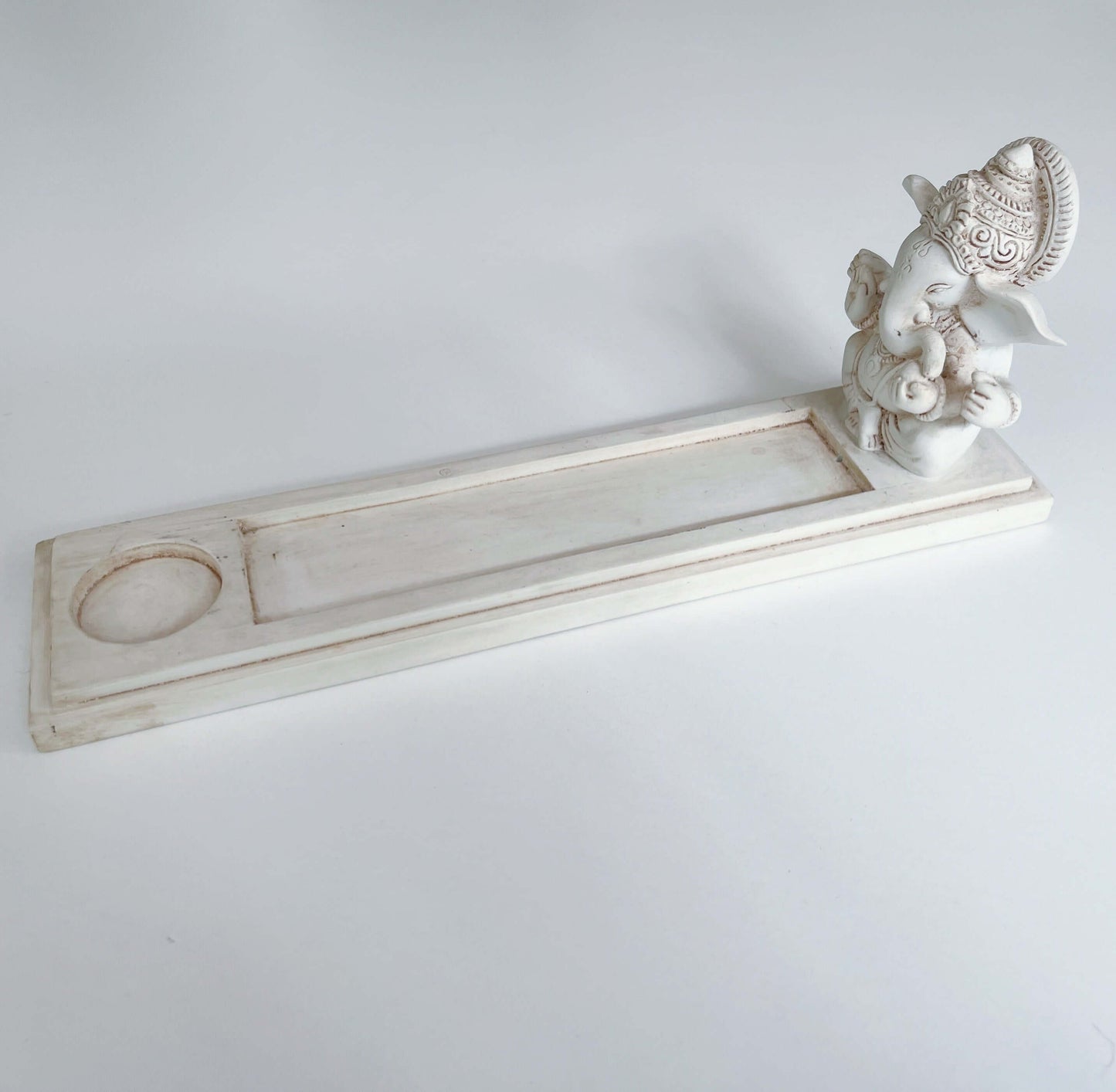 Side view of incense holder, Ganesha sits at one end of long rectangle, the remaining part is to catch the ash.