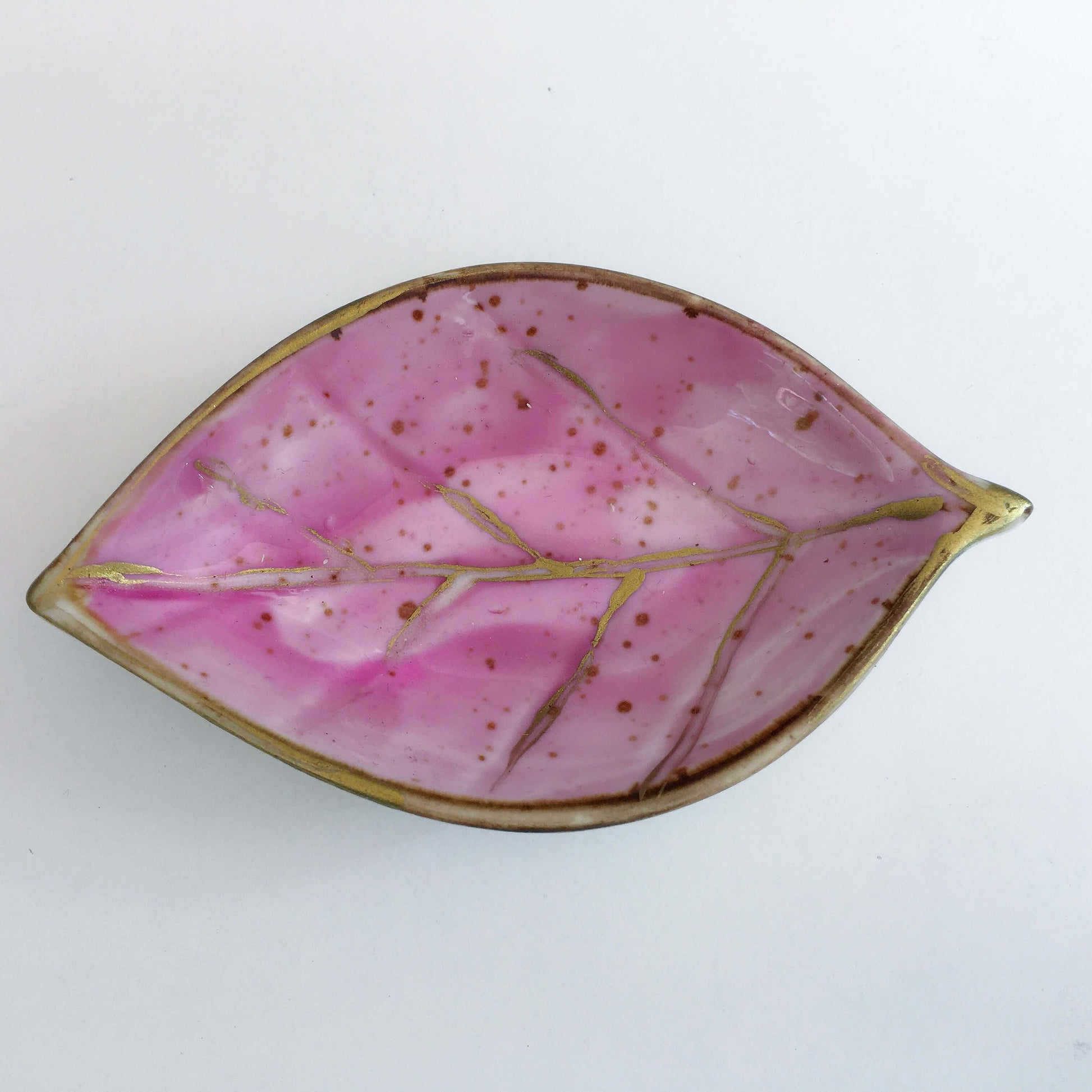View of plum painted ceramic leaf.
