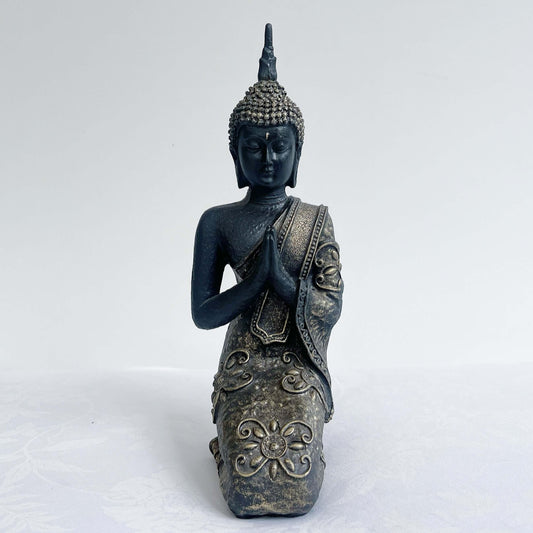 Front view of buddha kneeling, with ornate robes and detailing, ushnisha on head, washed black and silver painting.