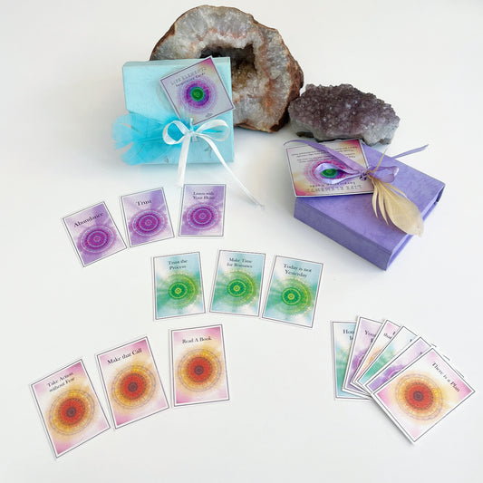 View of packaged decks against natural stone, with a few sample cards laid out in front in a fan shape.