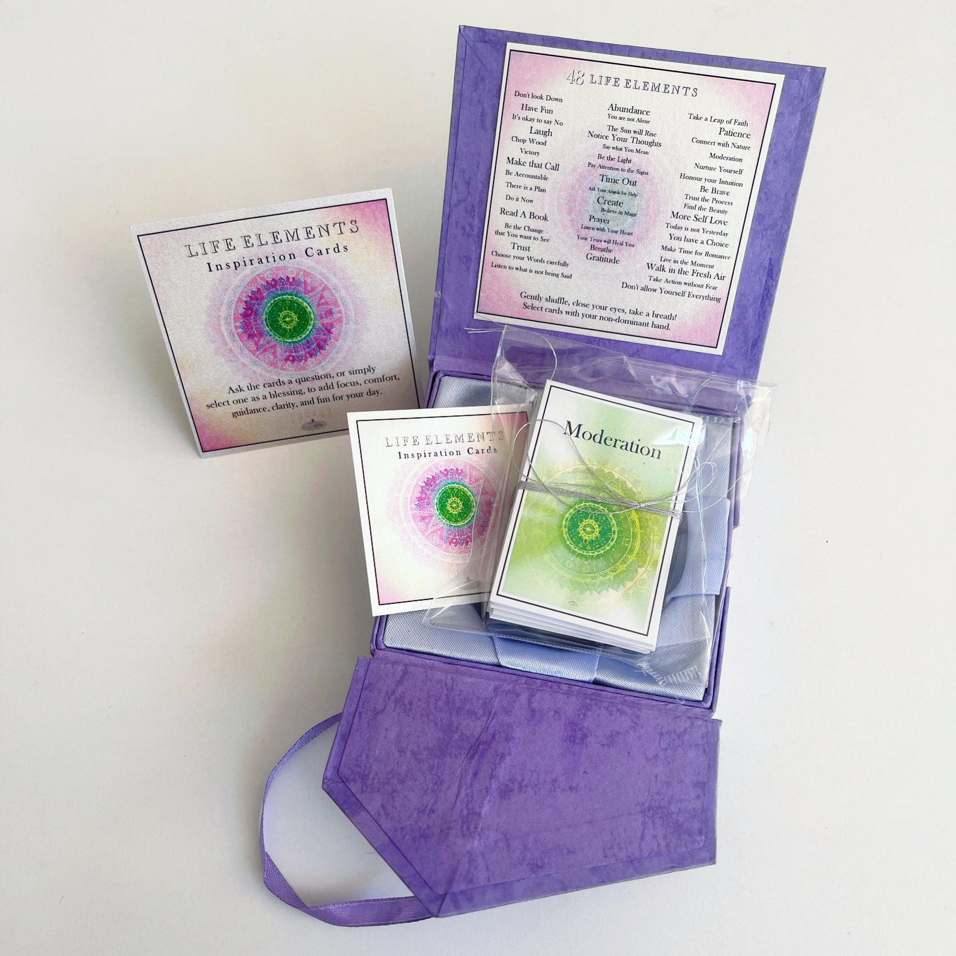 View of open box with the cards wrapped in plastic inside the box
