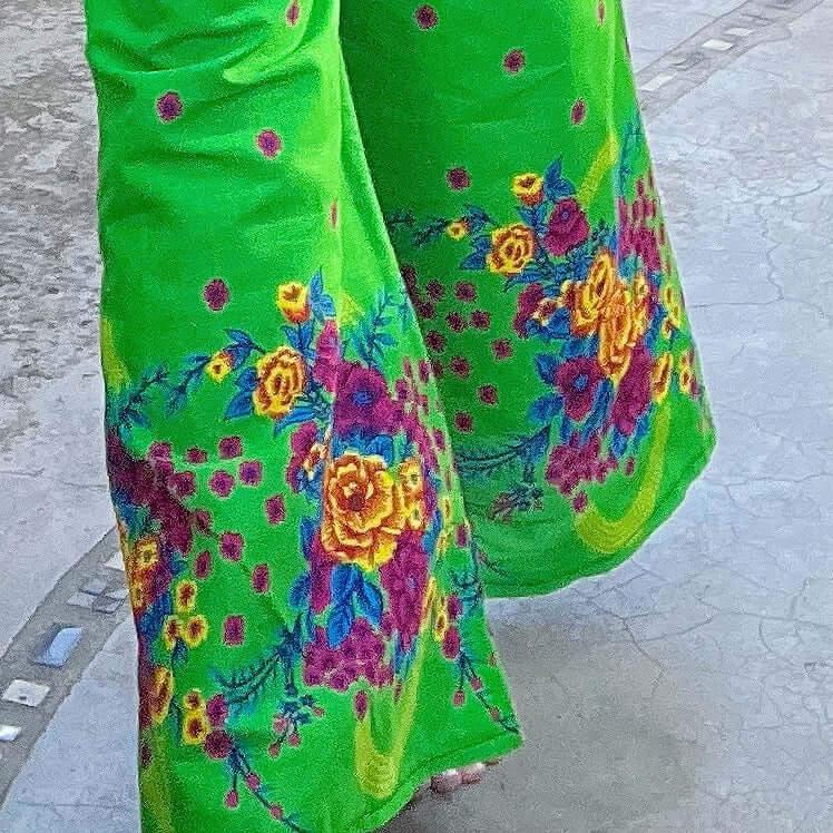 Detail of the pants bottoms, the bright colorful bold floral hem border leading up to a more sparse spray of floral prints.
