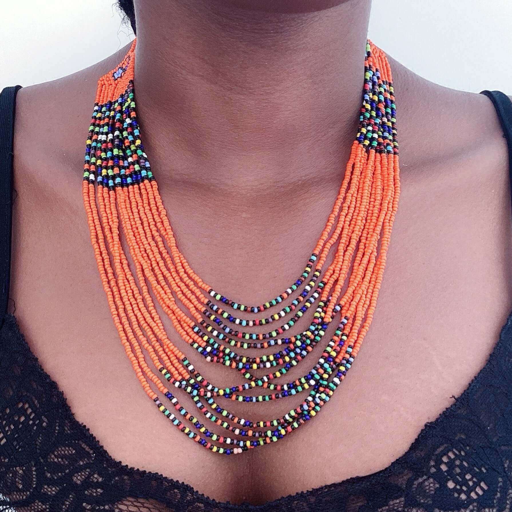 View of multi strand zulu beaded necklace in bands of orange and multi mix colors.