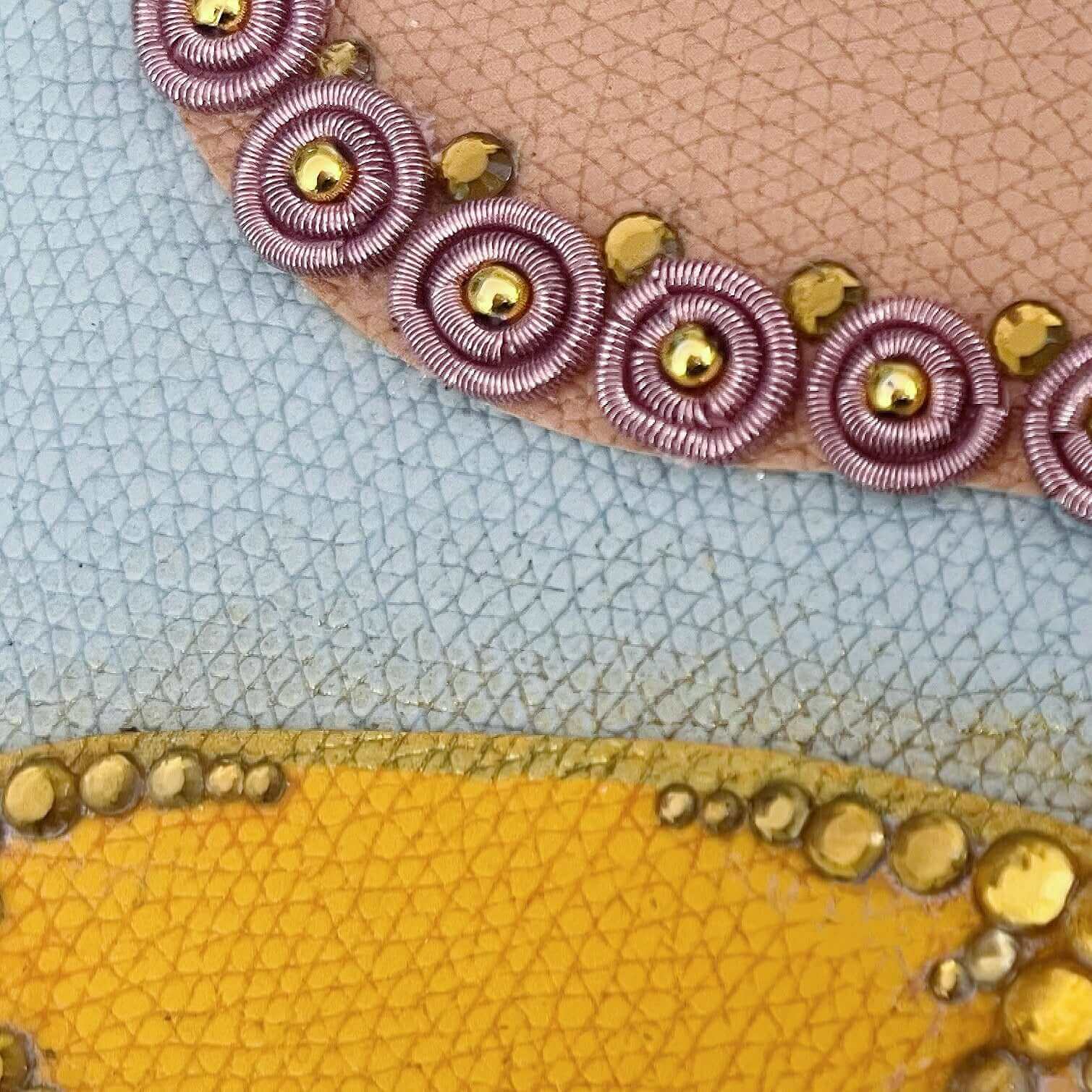 Detail view of journal showing the yellow blotch with gold crystals, and pink one with pink beaded charms.
