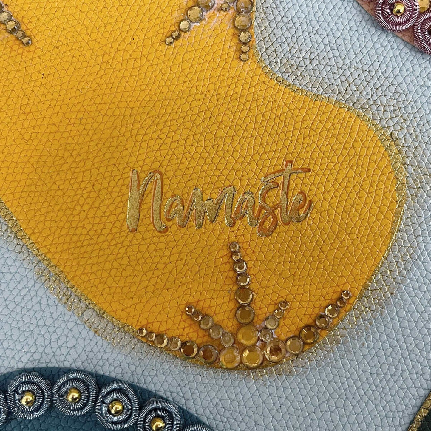 Detail view of journal showing the yellow blotch, with gold crystal decorations on the borders.