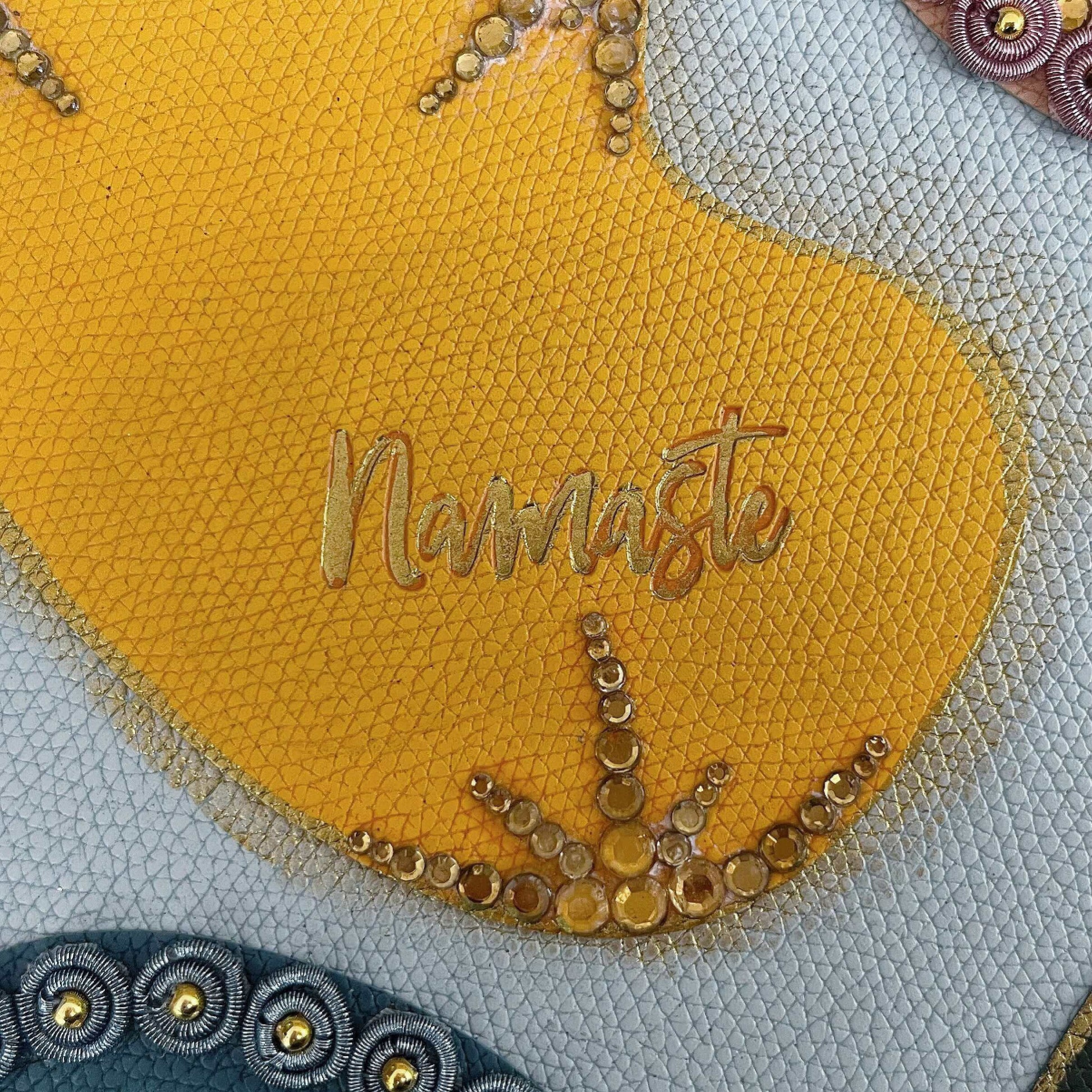 Detail view of journal showing the yellow blotch, with gold crystal decorations on the borders.