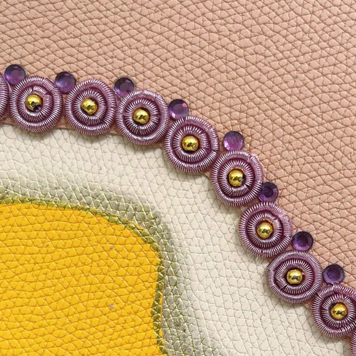 Detail view of journal showing the pink blotch, with pink beaded charms.