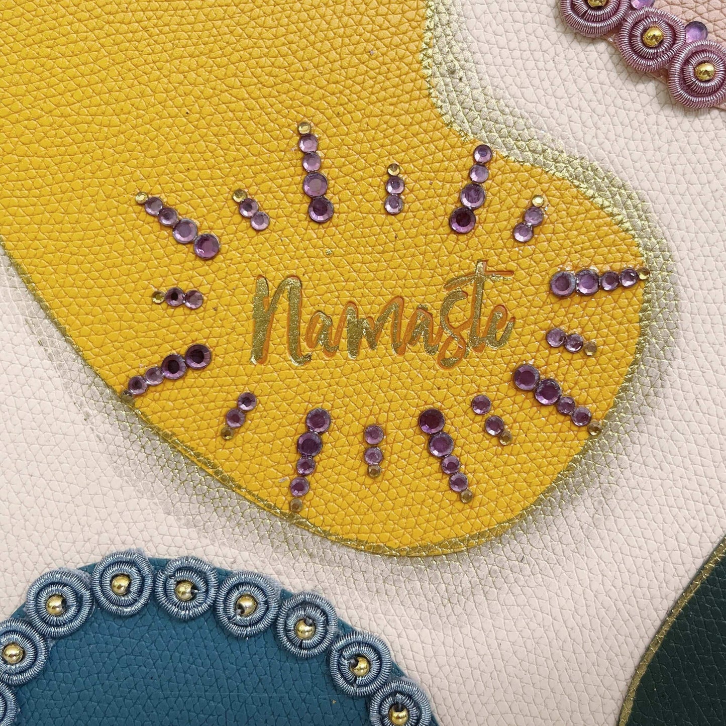 Detail view of journal showing the yellow blotch, with gold crystal decorations on the borders.
