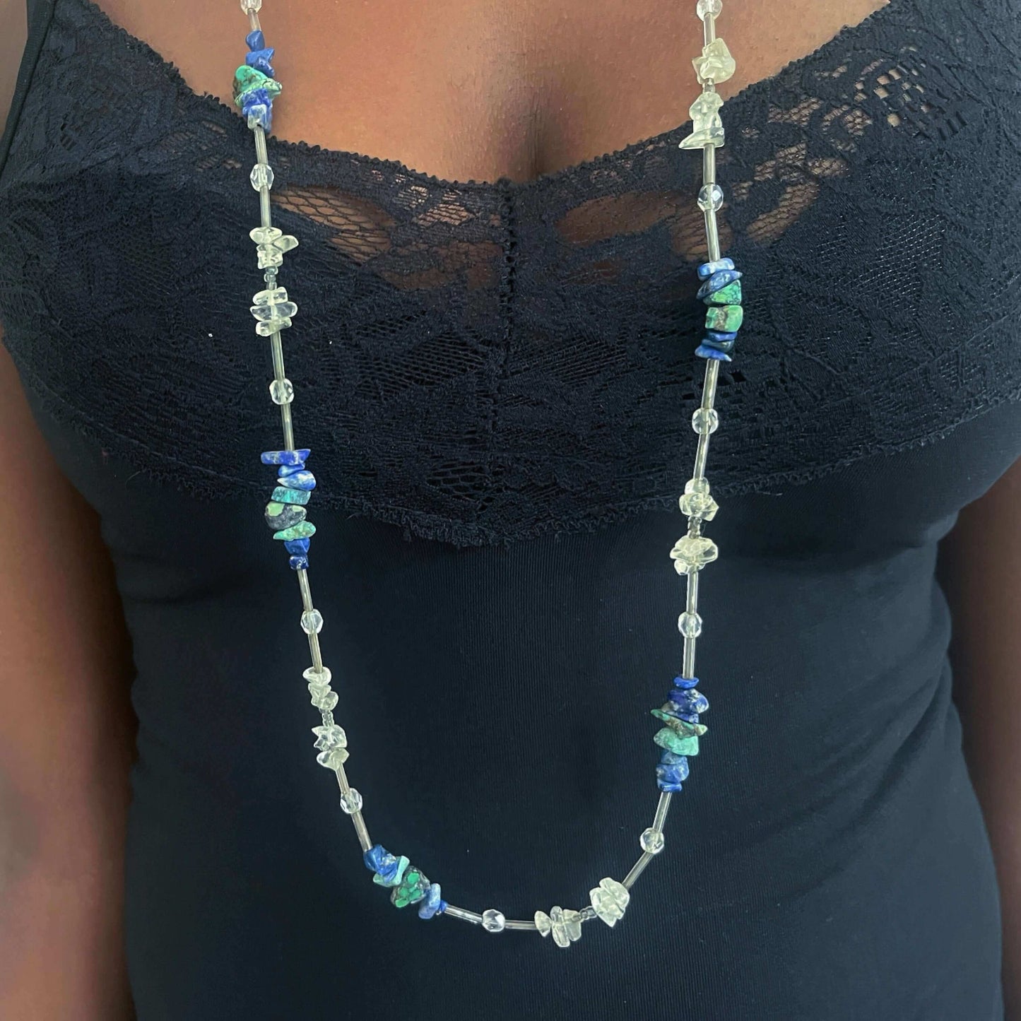 Detailed view of beaded necklace, tumbled clear quartz, lapis lazuli stones and glass beads.