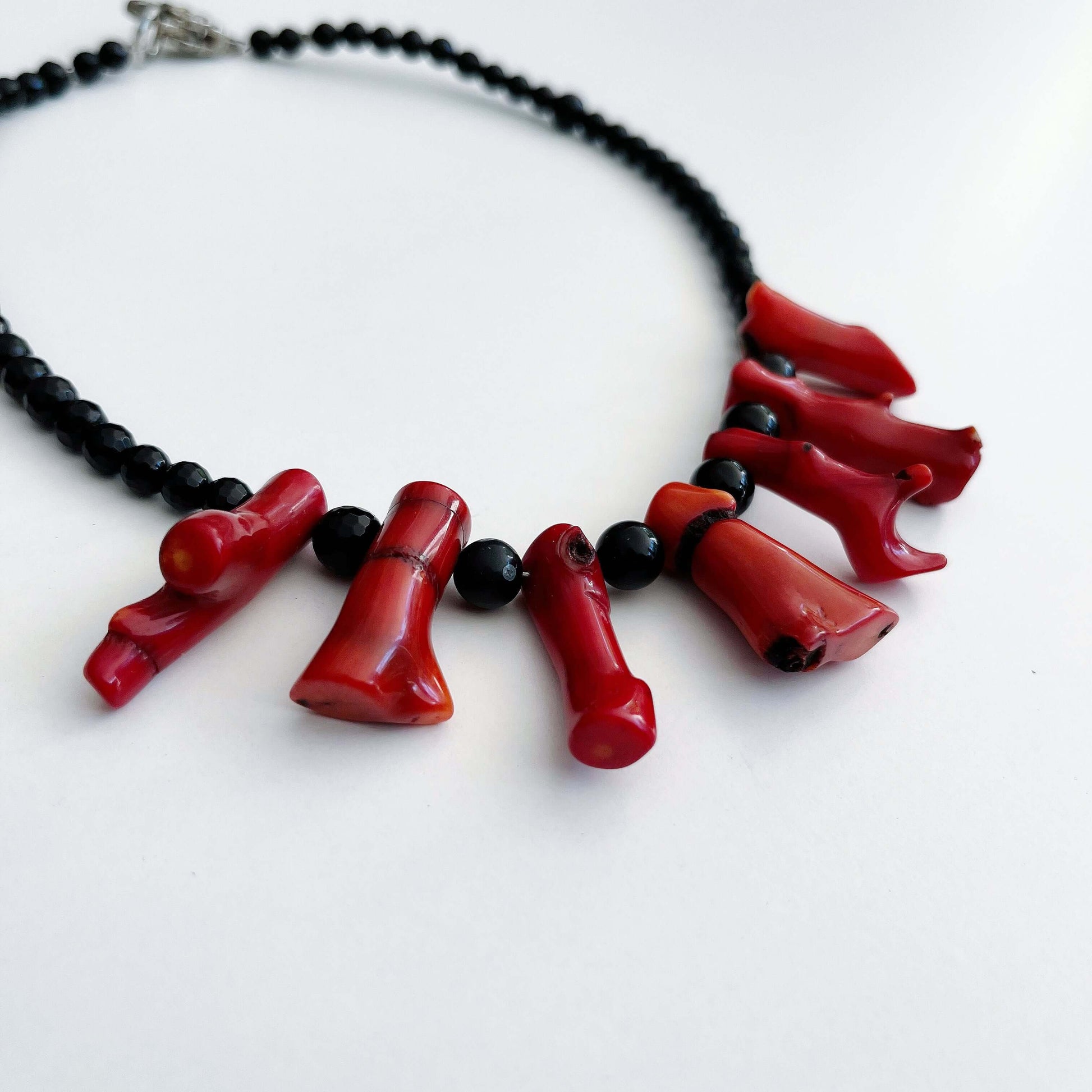 Side view of the Coral and Obsidian necklace.