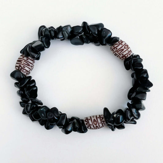 Top view of double-strand tumbled chip bracelet, with a white and maroon African style bead positioned in 3 places.