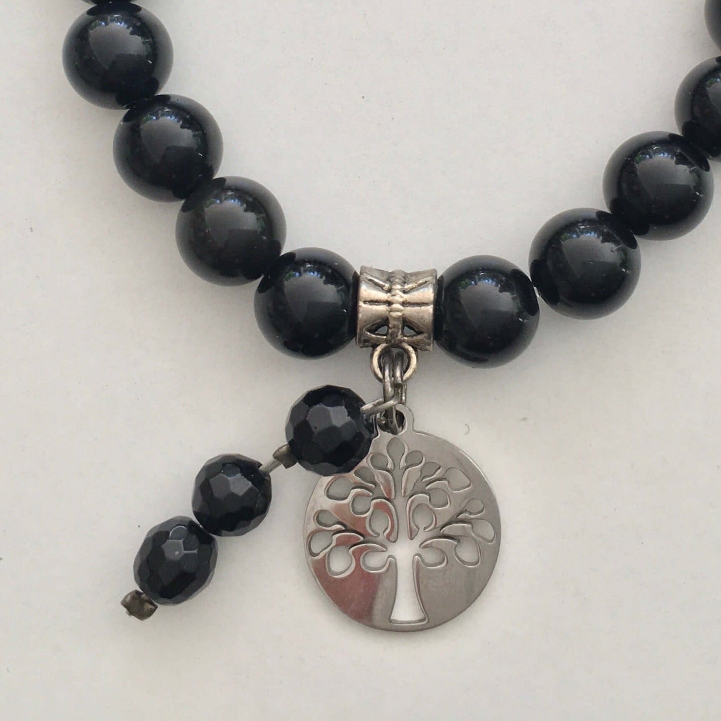 Detail view of beaded bracelet with matching 3 bead dangle and Tree Of Life attached to silver bead.