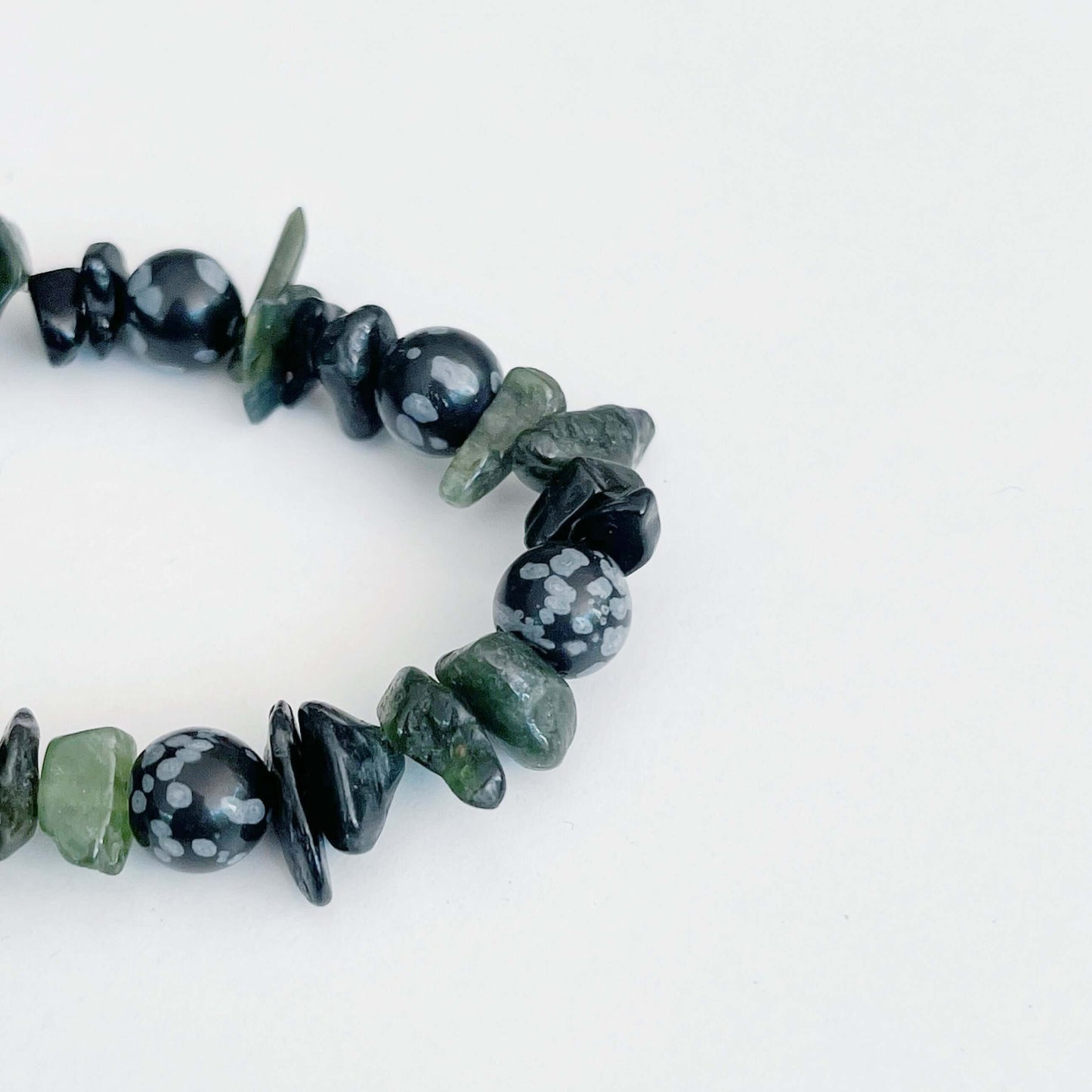 Detail view of the tumbled semi-precious stones, blacks and greens.