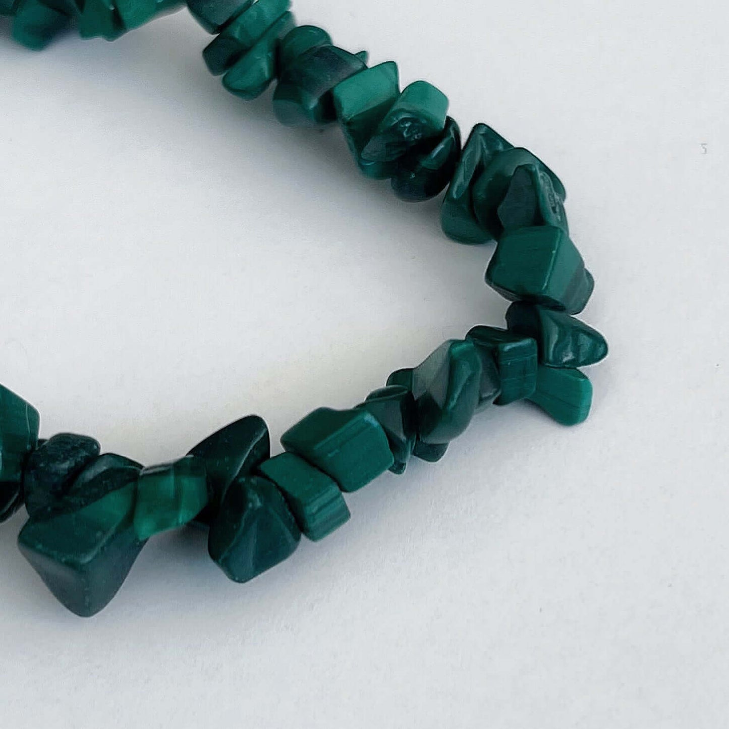 Detail view of the tumbled semi-precious stones, shades of deep teal and green.