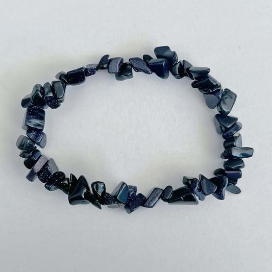 Top view of the tumbled semi-precious stones, shades of black and deep grey with some sparkling stones in between.