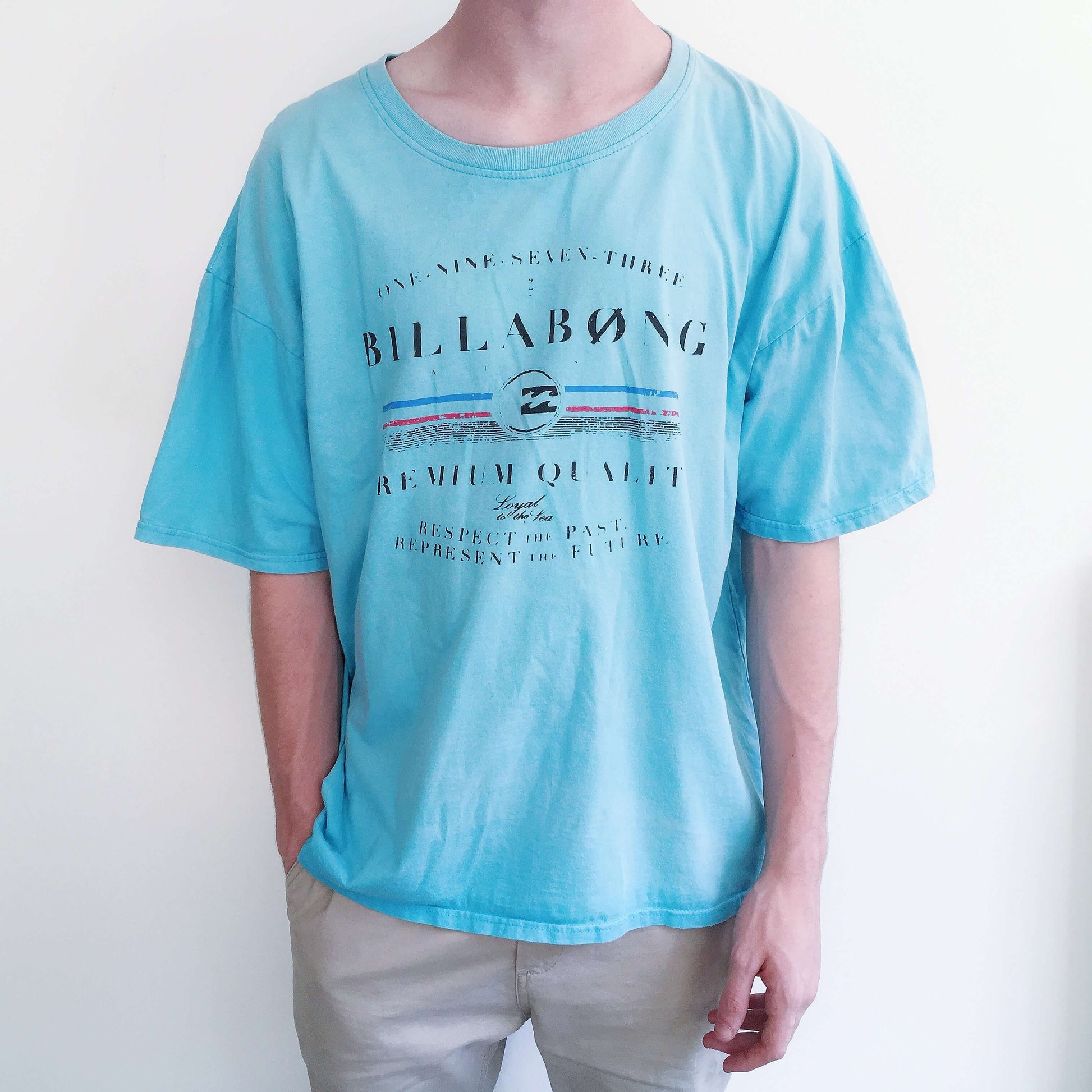 Front view of turquoise, drop shoulder tshirt, with black printing on the front.