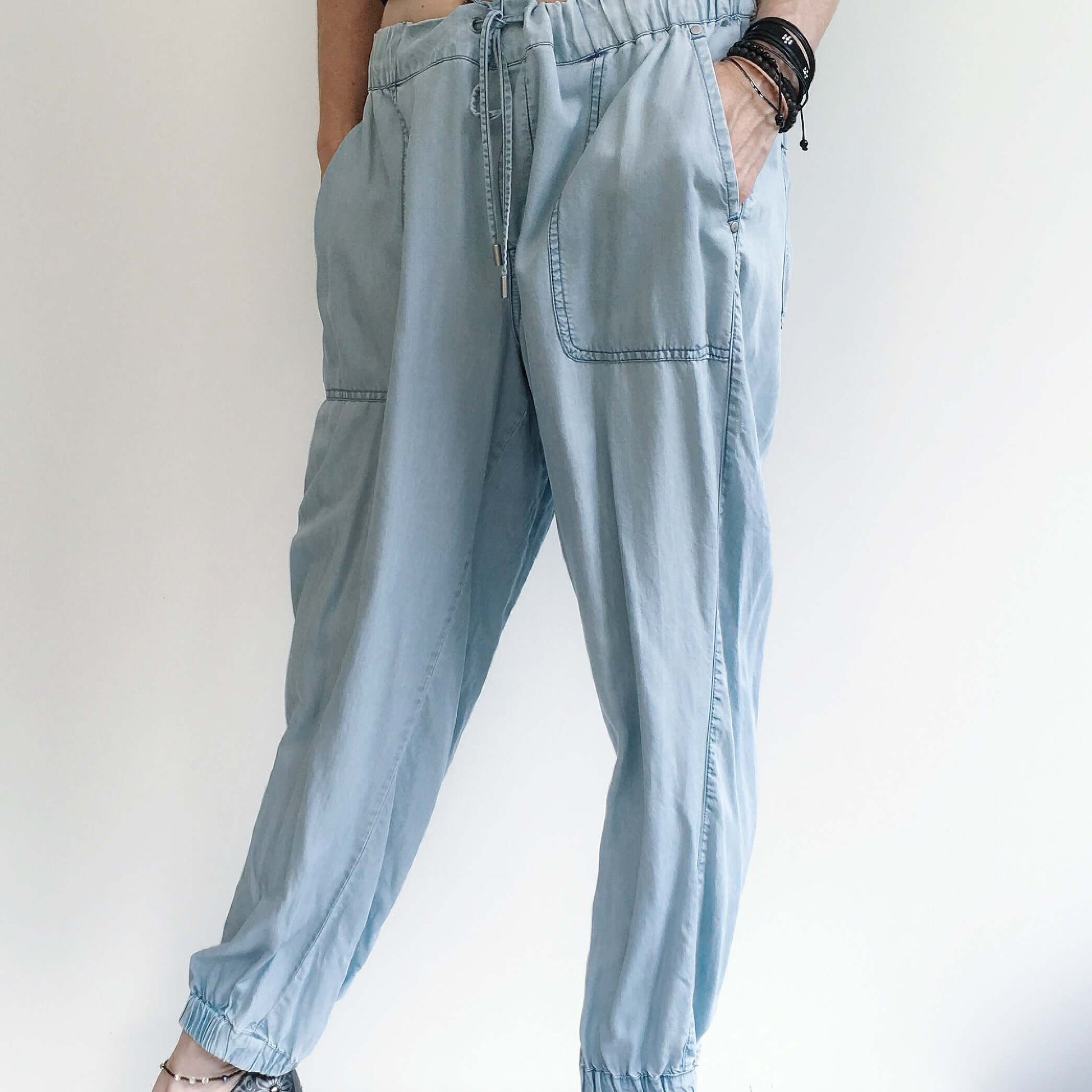 Front view of pale blue elasticated pants with drawstring, deep side pockets, and elasticated at ankles.