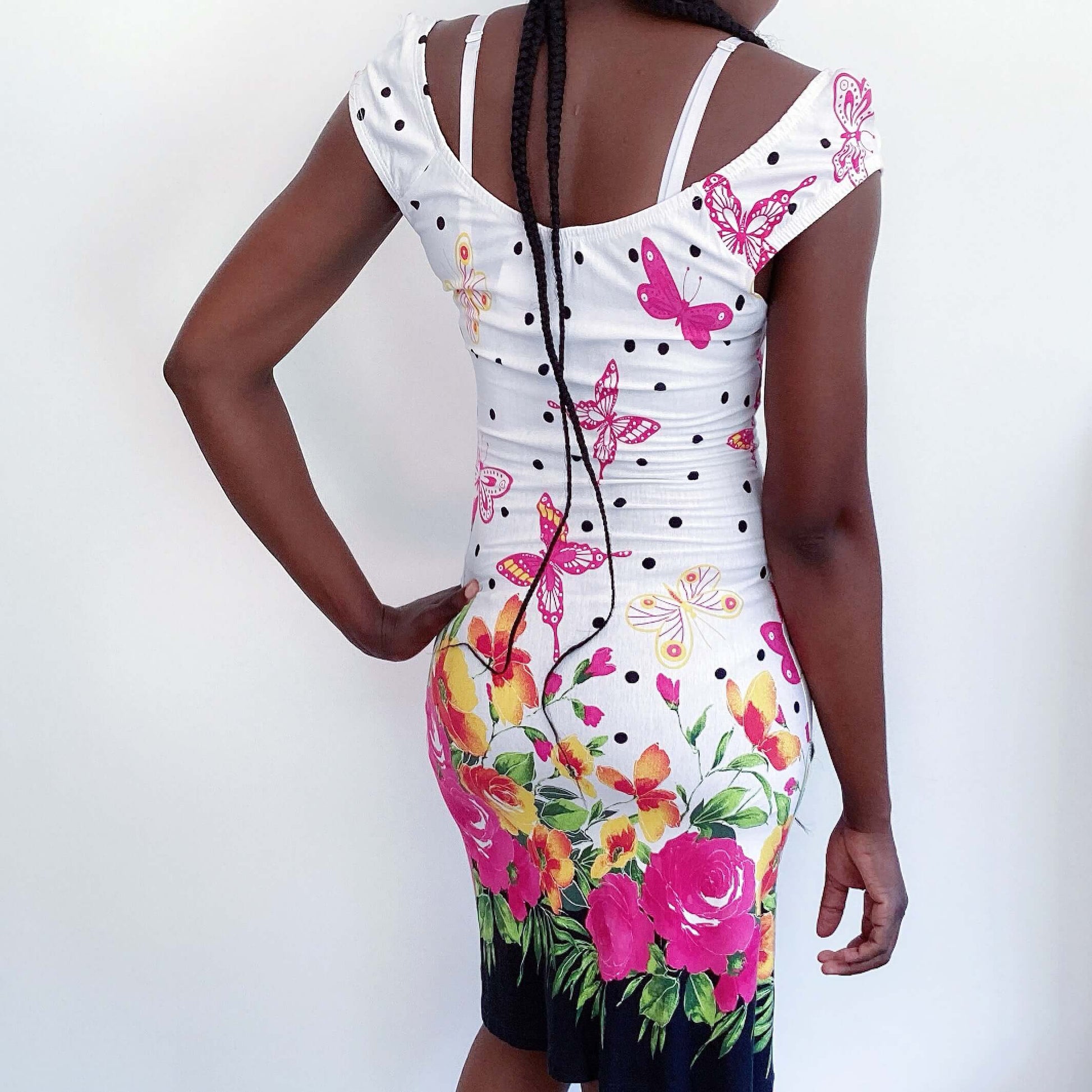 Back view of white cotton mini dress with pink butterflies and roses, pink ribbon in the center under bust, and black dots.