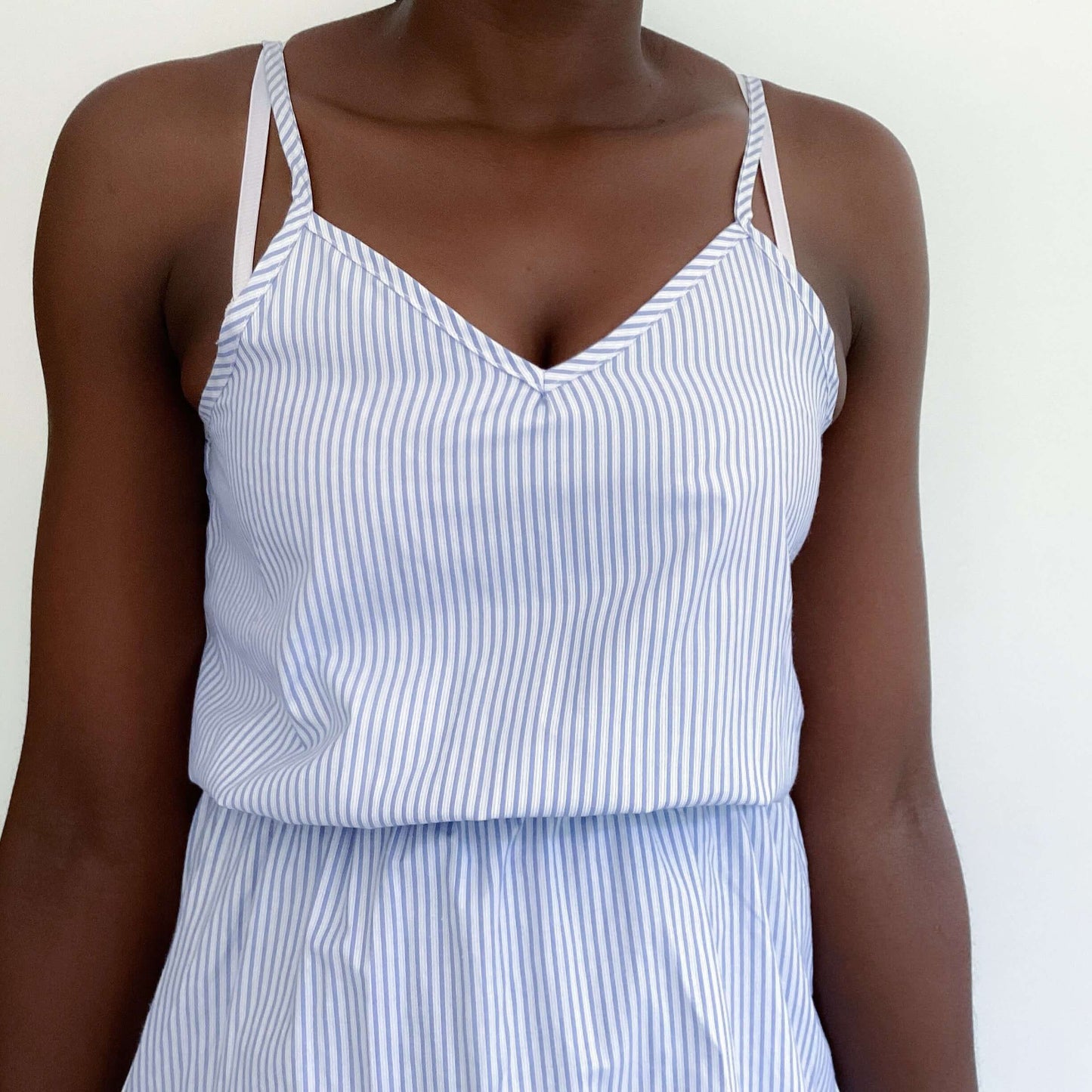 Pale blue and white striped v-neck dress, above knee, thin straps and elasticated waist, front view.