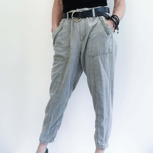 Front view of pale khaki elasticated pants with belt, side pockets, and elasticated ankles.