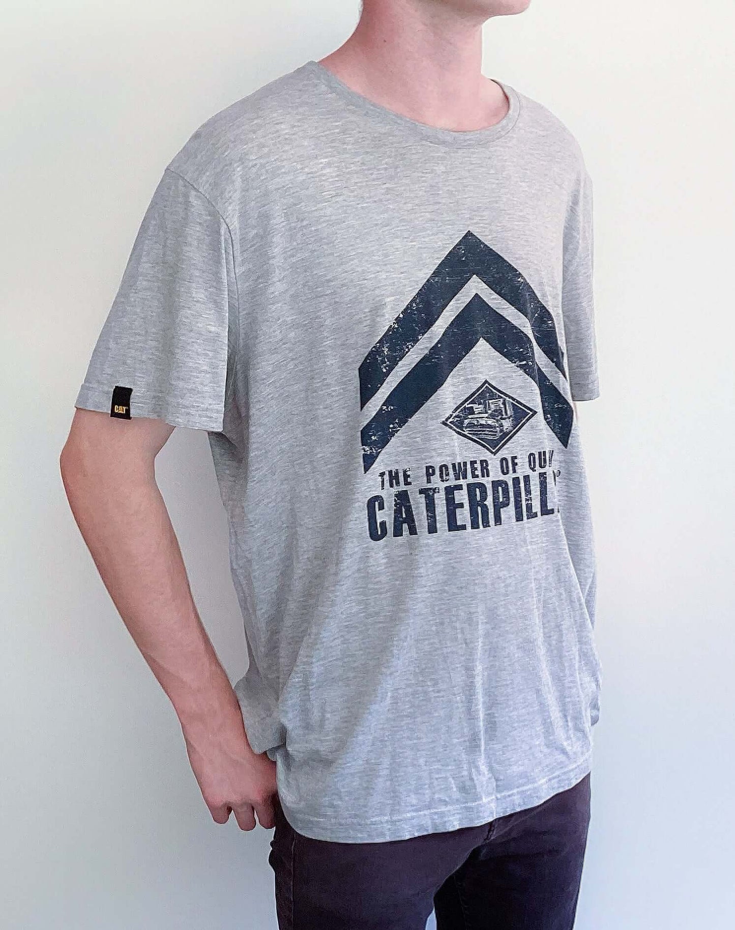 Side view of light grey, drop shoulder tshirt, black printing of caterpillar across the front.