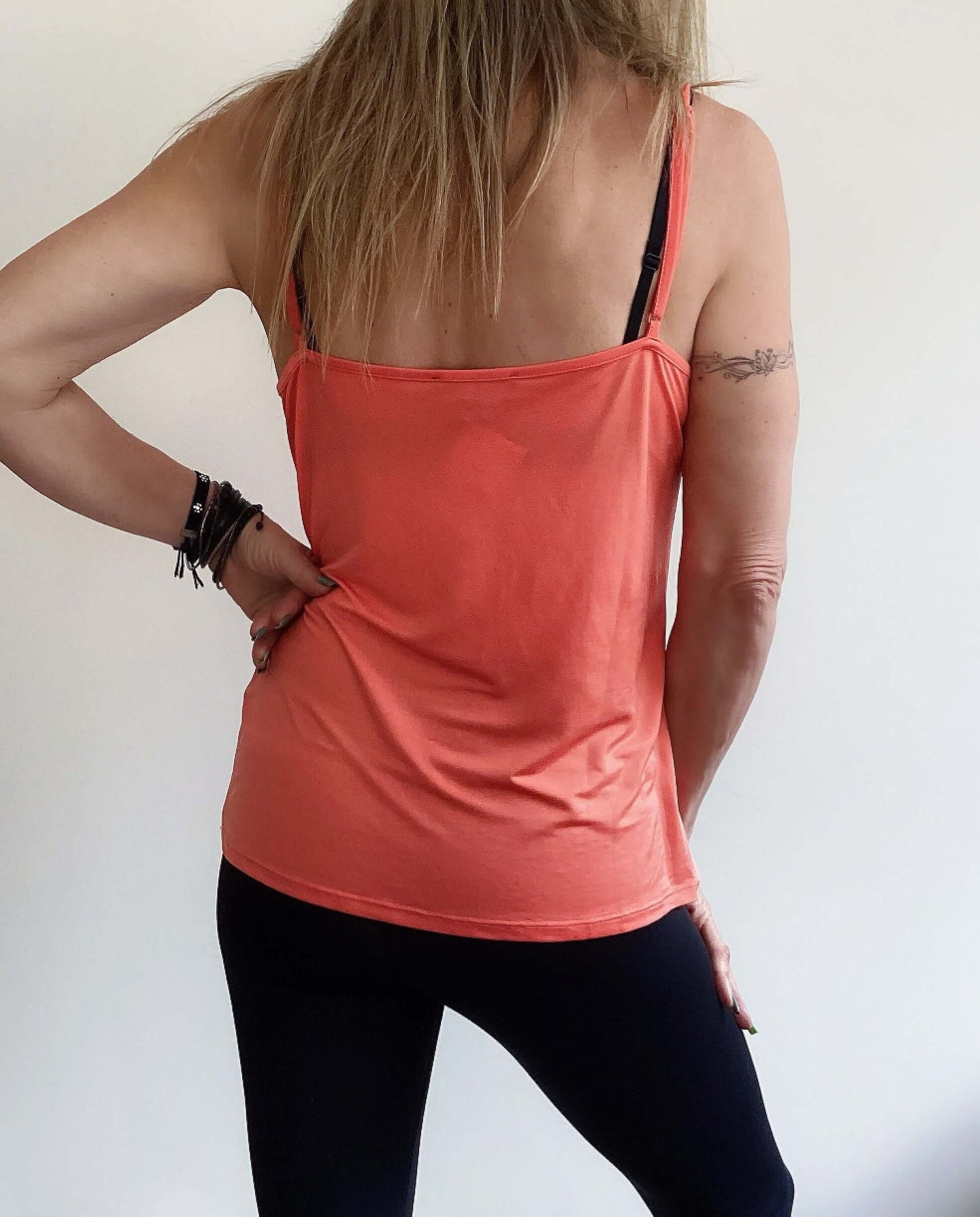 Back view of tangerine camisole, stretch fabric, hip length, adjustable straps.