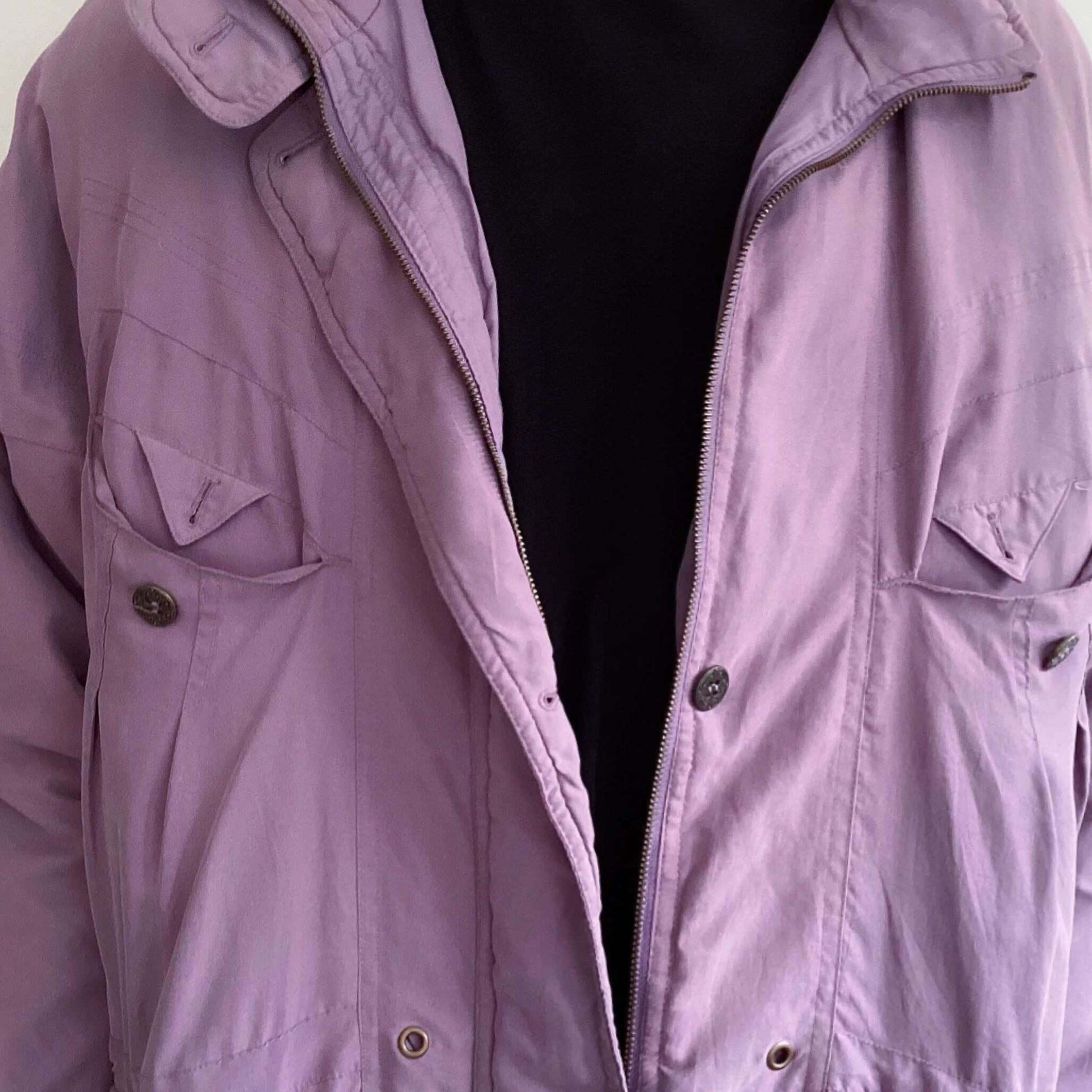 Detail view of dusty purple snow jacket, mid thigh length, zipper and buttons.