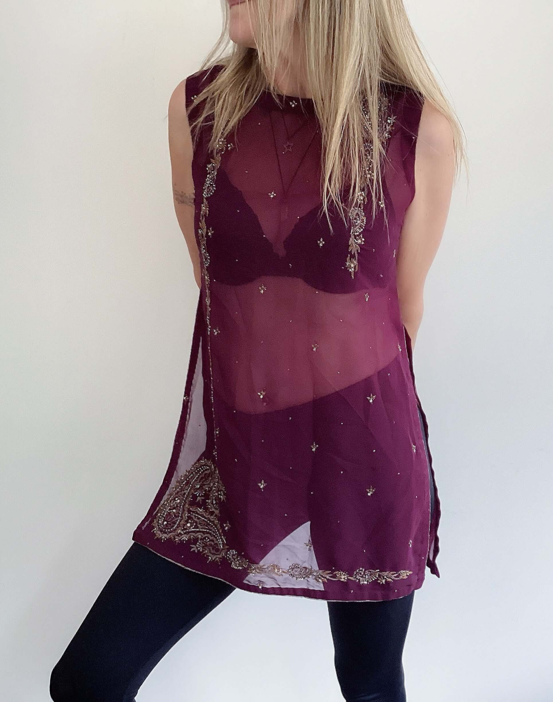 Front view sleeveless plum tunic, gold embroidery borders and bust sides, gold flecks dotted at front, high neck, side slits.