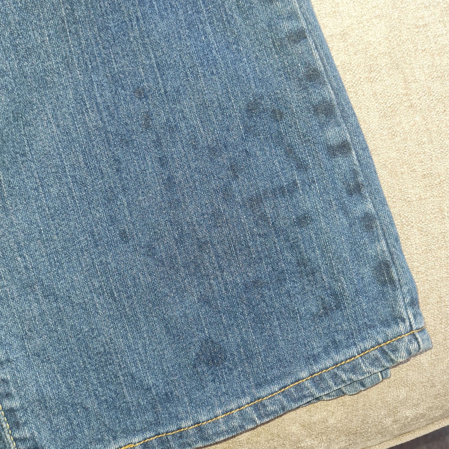 View of faded glue stains near left hem in the front.