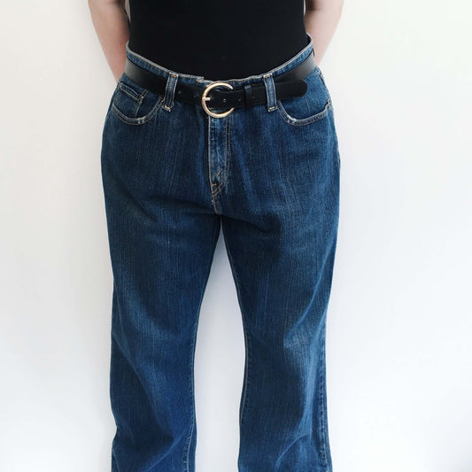 Front view of blue jeans belted at the waist with zip.