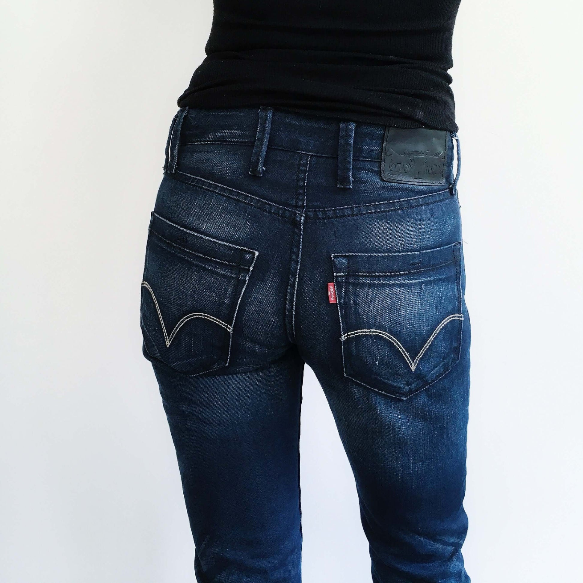 Back view of dark blue jeans, hip to knee.