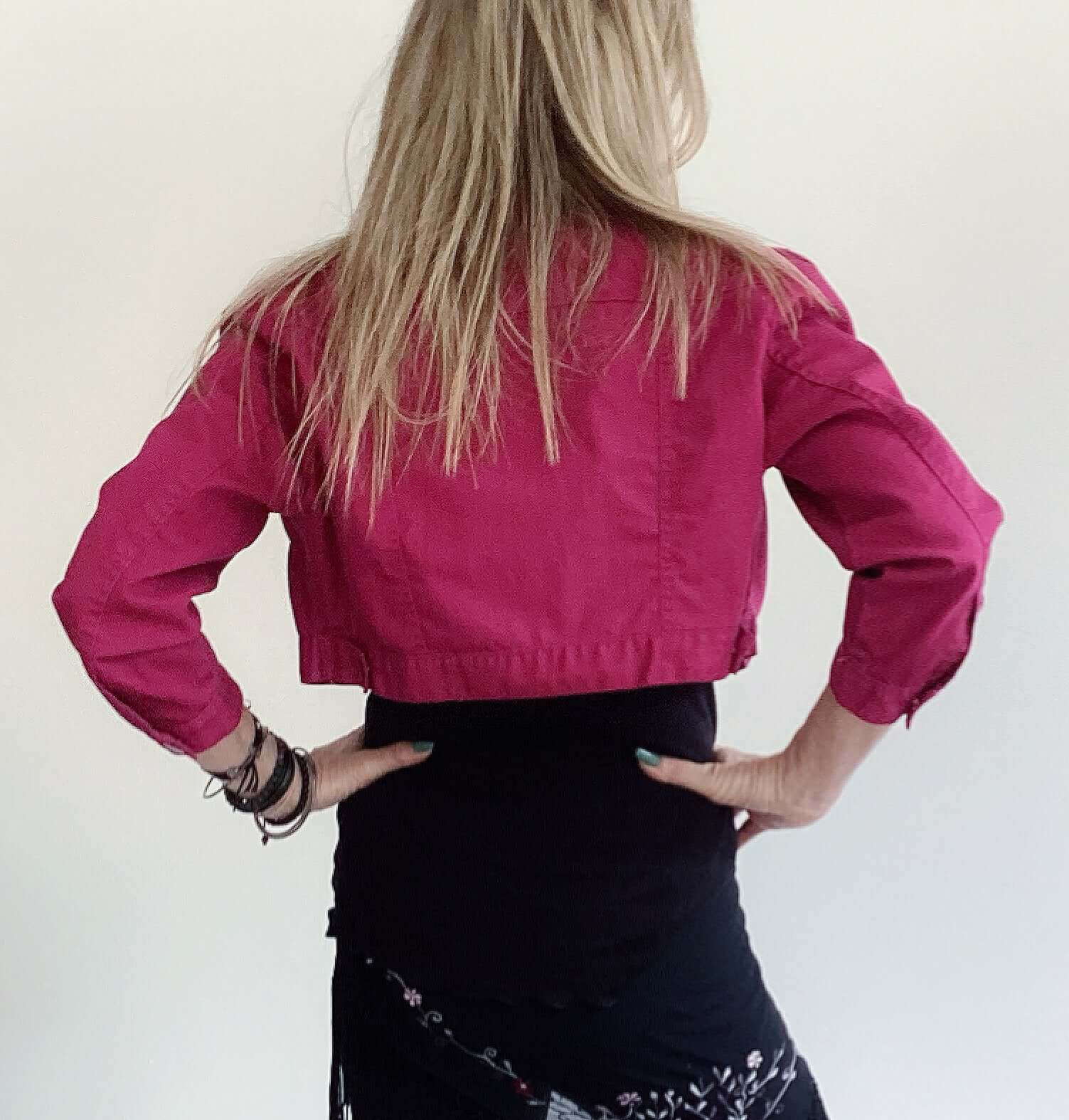 Back view of plum button up crop jacket, three quarter sleeves, side breast pocket and plum buttons.