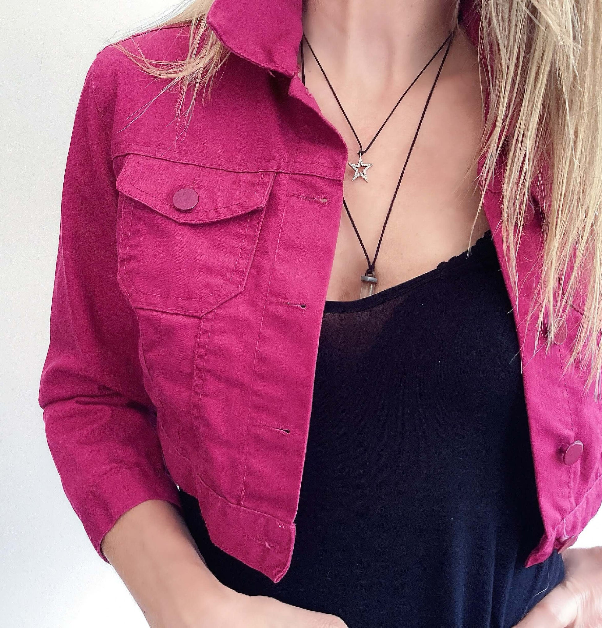 Detail view of plum button up crop jacket, three quarter sleeves, side breast pocket and plum buttons.