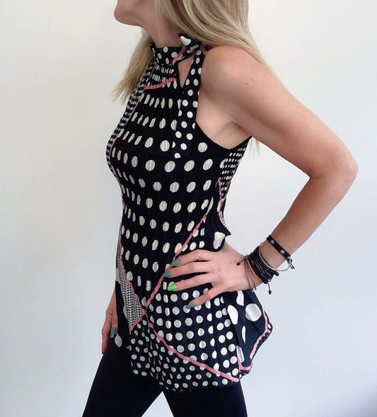 Side view black and white polka dot top, pink piping accents, tied at the neck with matching fabric, length upper thigh.