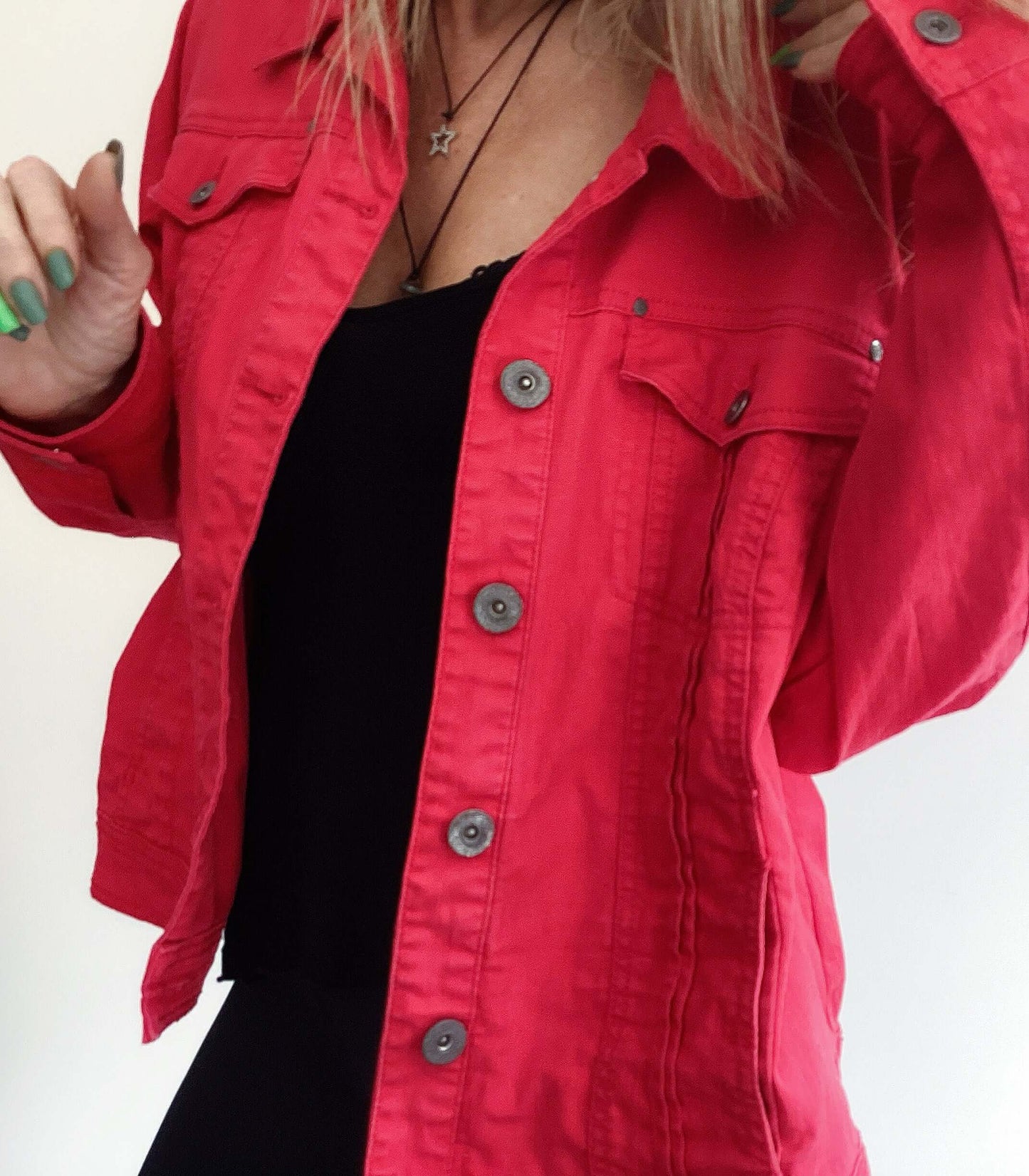 Front detail view of red denim jacket, hip length, brass buttons.